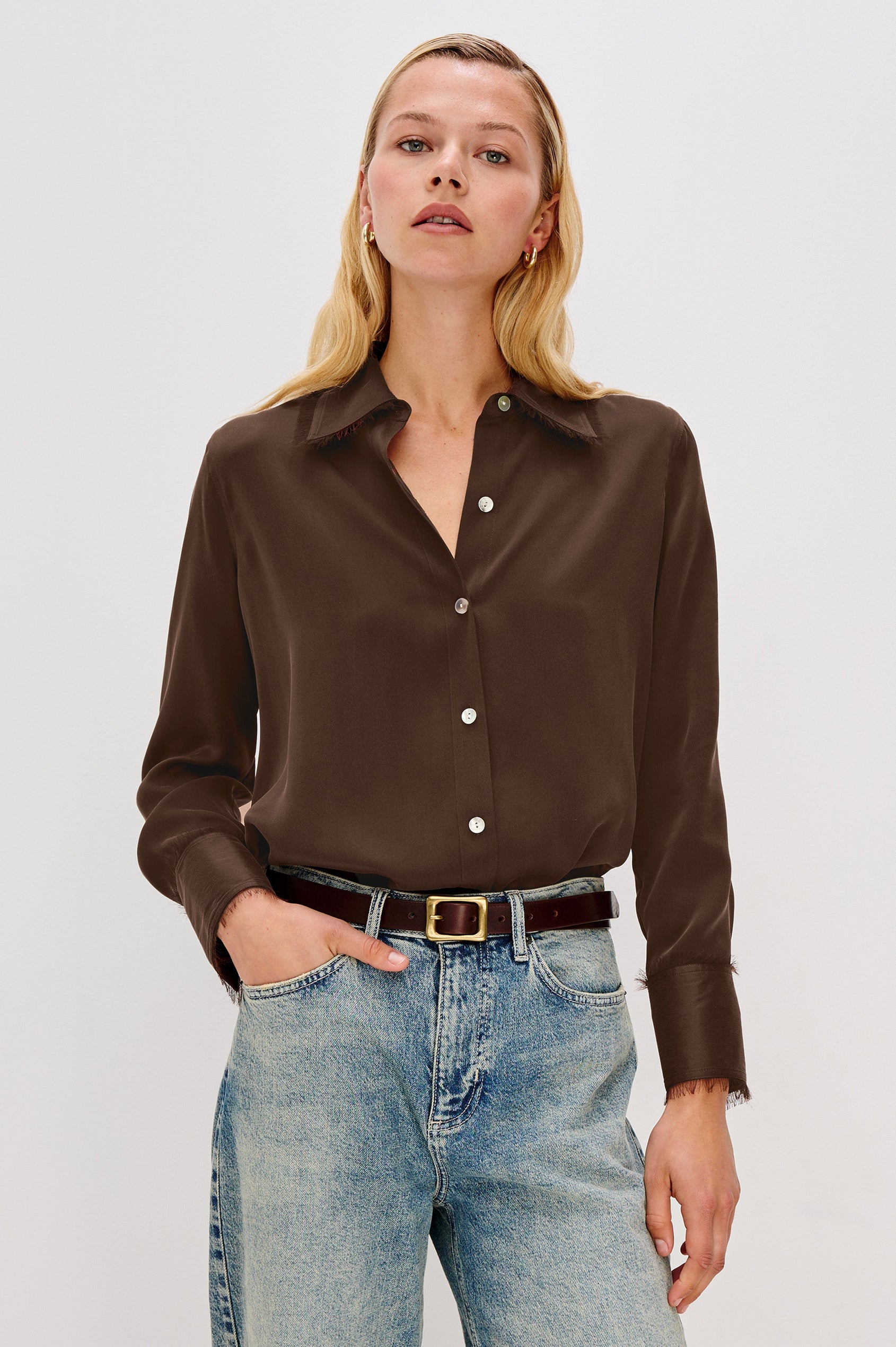 The Abbey is a silk charmeuse button-down shirt with raw edge detailing at the collar and cuffs, with a relaxed fit in Espresso Colorway - Front View Featured on Model, Tucked in Styled with Belt
