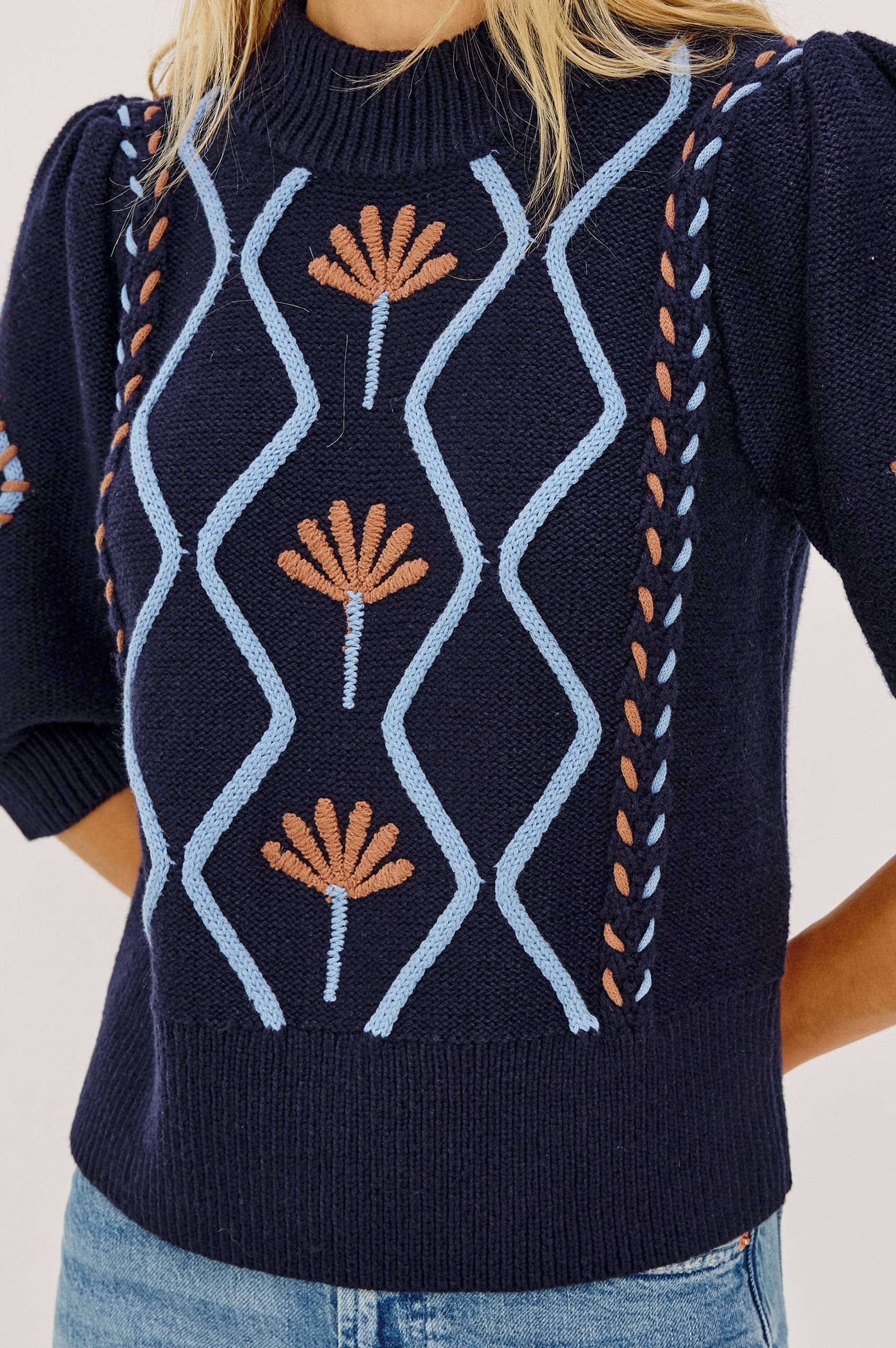 Addy Sweater in Cable Knit With Mock Neck, Relaxed Fit, and Elbow-Length Puff Sleeves in Floral Cables - Upper Body Front View Featured on Model