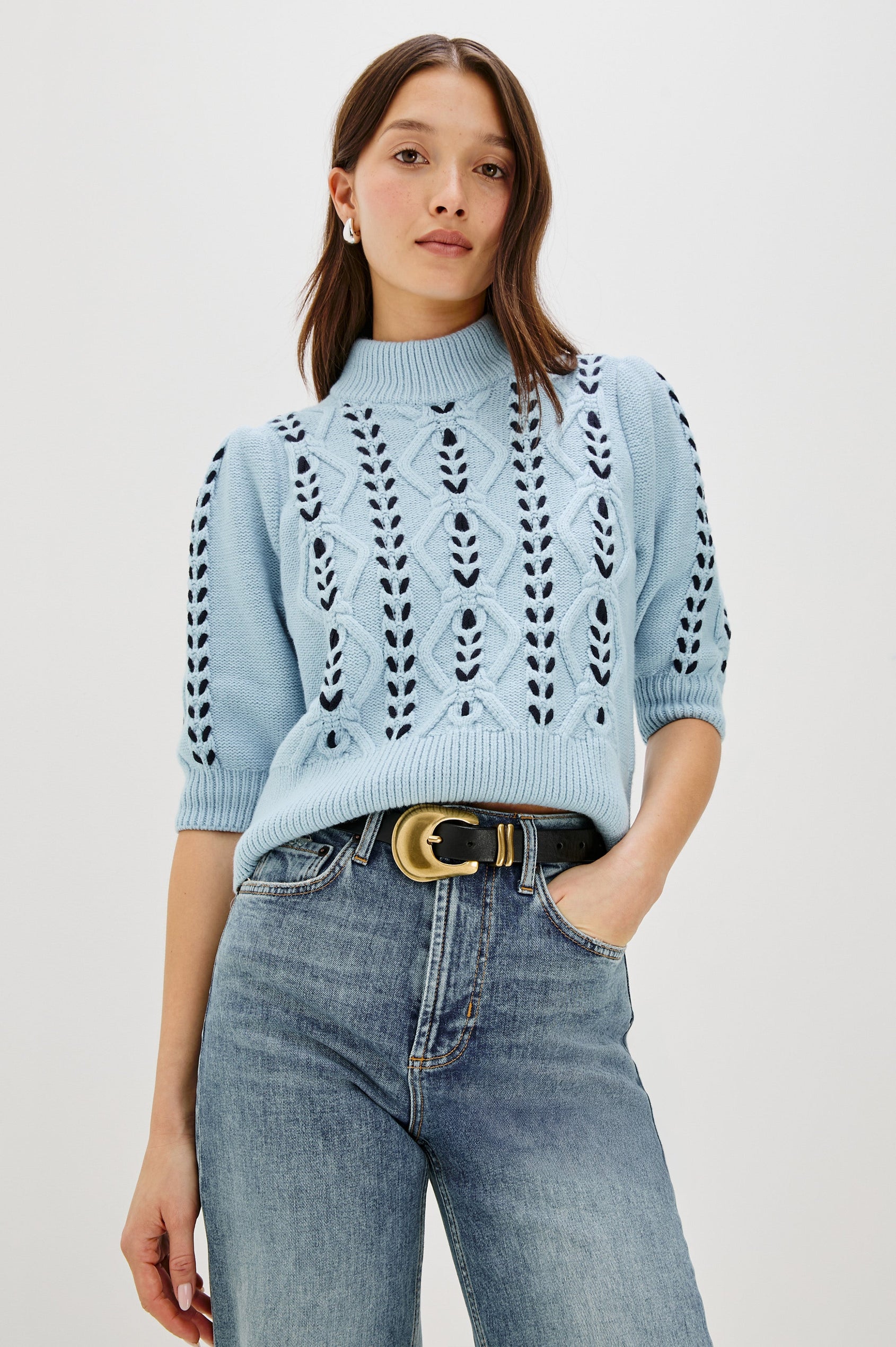 Addy Three Quarter Sleeve Sweater with Contrast Cable Knit Stitching and Ribbing at the Neck, Armhole, and Bottom Hem in Sky Navy Cables Colorway - front view on model