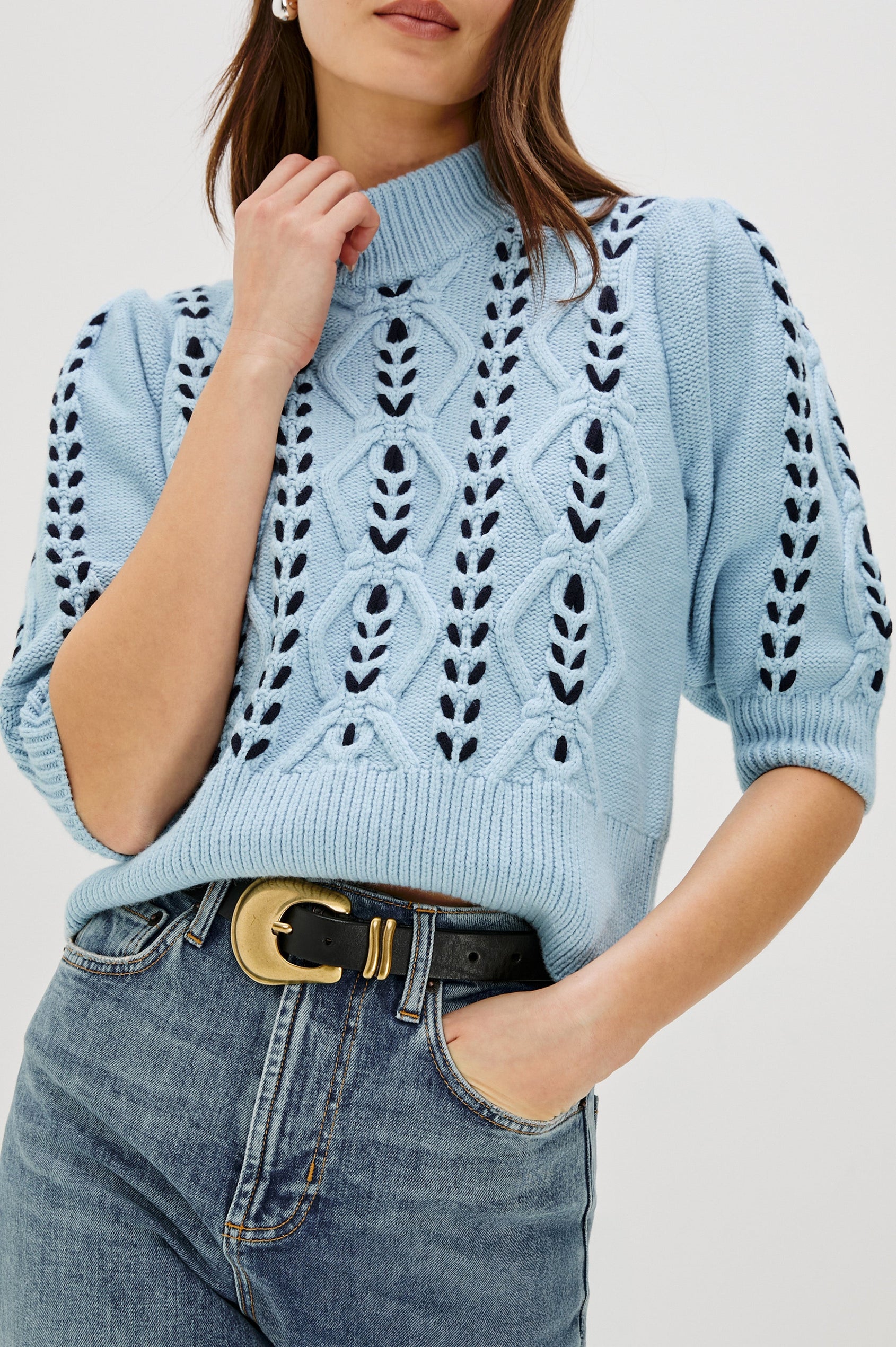 Addy Three Quarter Sleeve Sweater with Contrast Cable Knit Stitching and Ribbing at the Neck, Armhole, and Bottom Hem in Sky Navy Cables Colorway - Close up of details on model