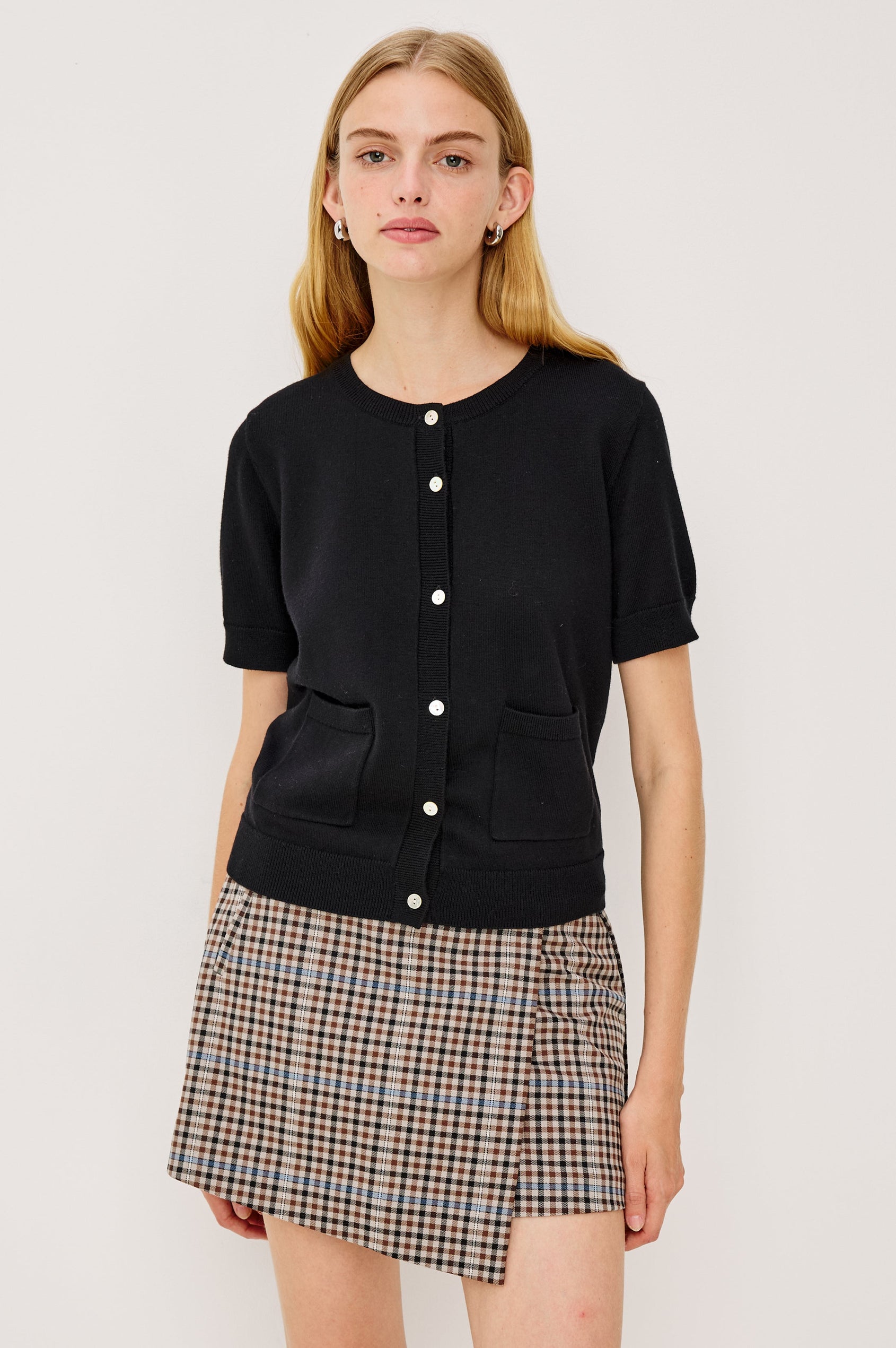 Aisley, a short-sleeve cotton-cashmere sweater with a semi-fitted silhouette. The sweater features a round neckline and is accented with a row of elegant pearl buttons down the front. Front View on Model