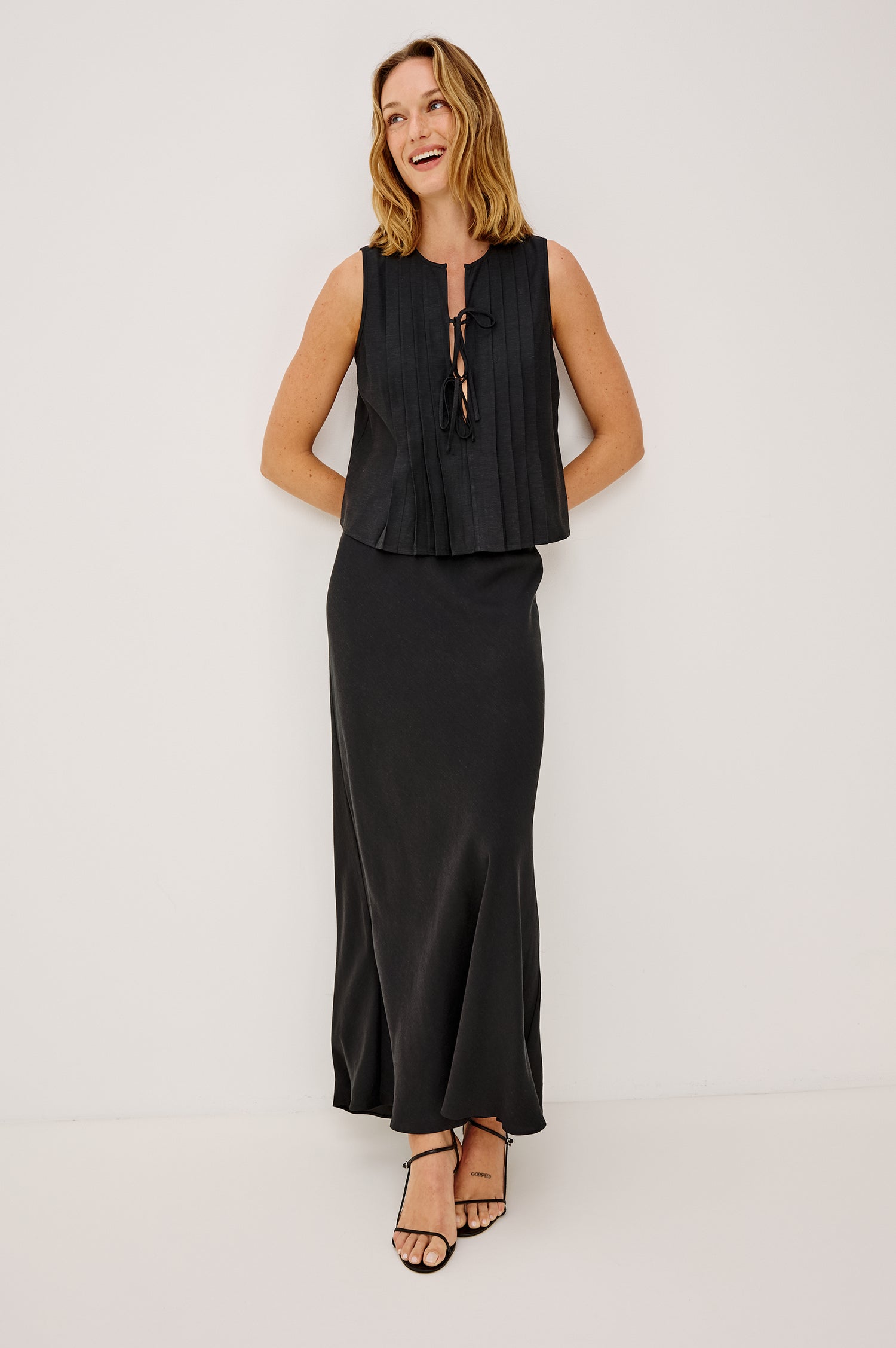 Aja Sleeveless Top in Linen With Plunging V-Neckline, Center-Front Ties, and Front Pleats in Black Linen Colorway - Full Body Front View Featured on Model