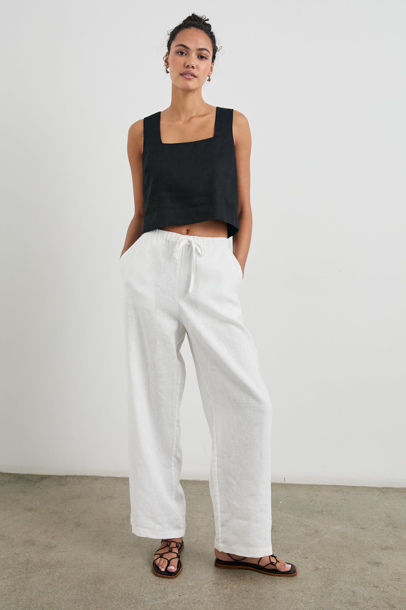 Akira Sleeveless Crop Top with Square Neckline and Wide Shoulder Straps in Black Colorway - Front Full Body View Featured on Model 