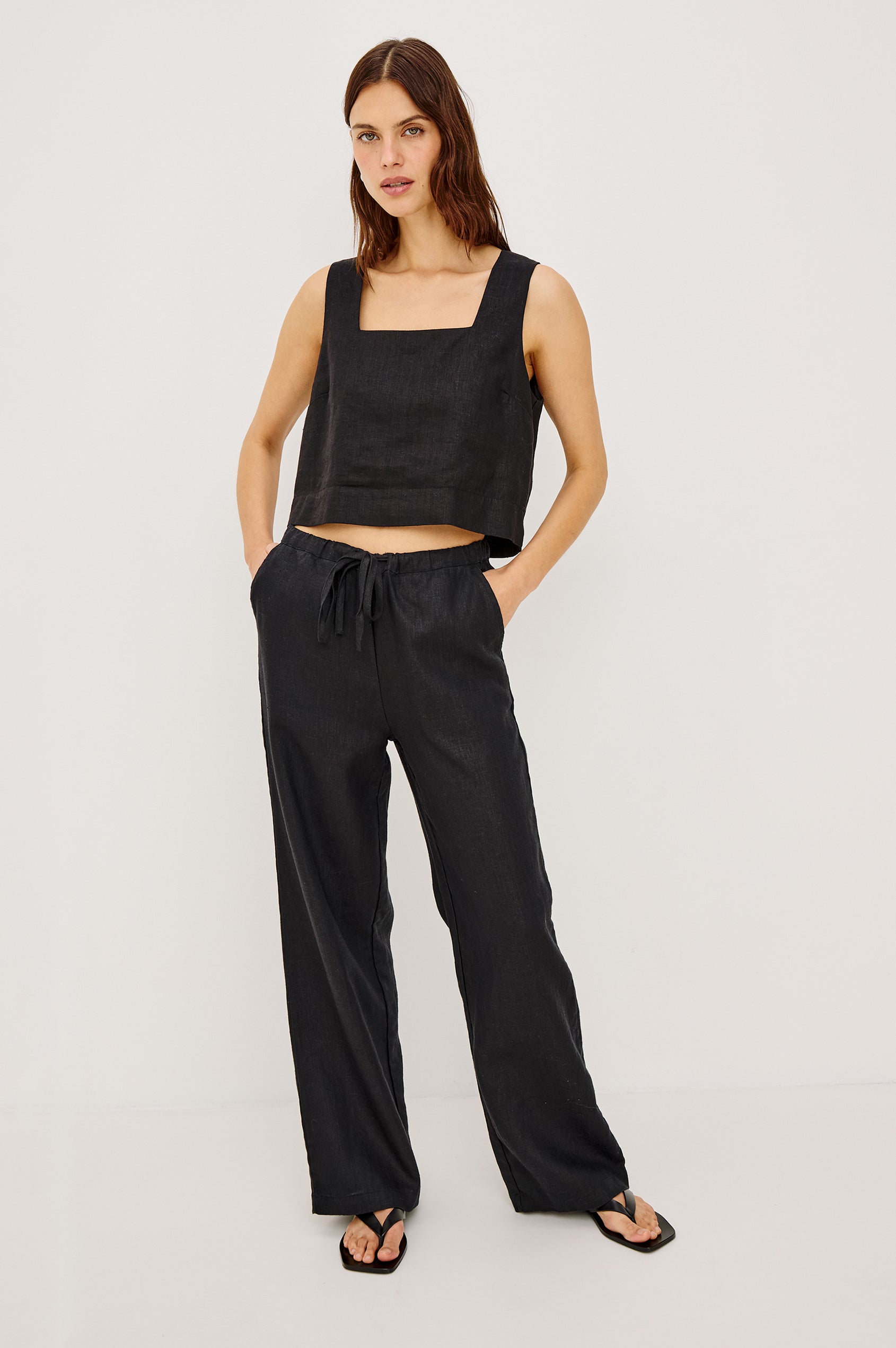 Akira Sleeveless Crop Top with Square Neckline and Wide Shoulder Straps in black Colorway - Front View Featured on Model