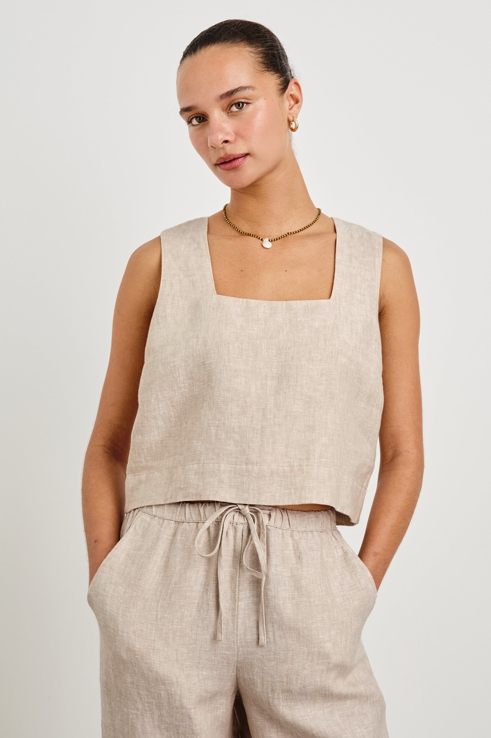 Akira relaxed fit linen crop top with wide straps in Heathered Flax - front view on model with hands in pocket
