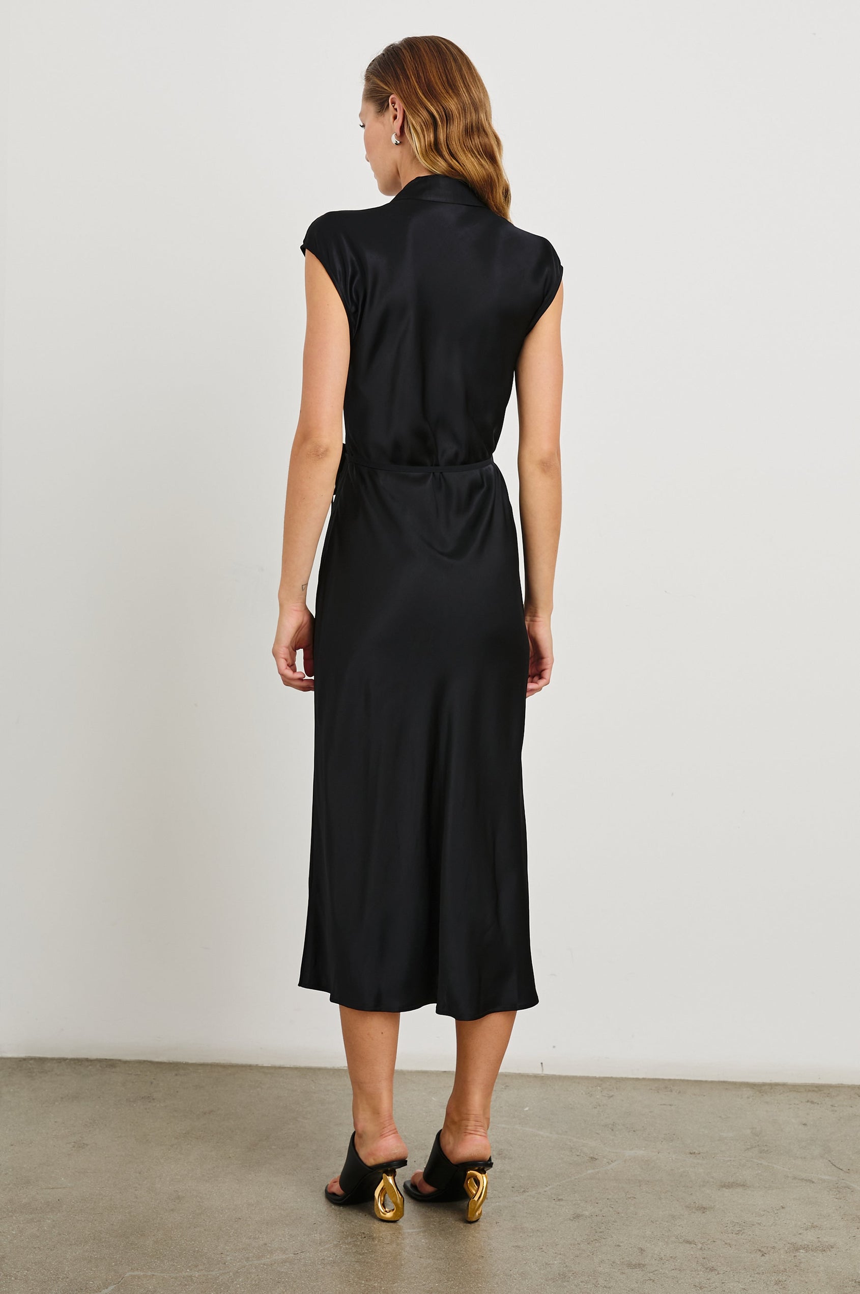 Alai Short Sleeve Midi Wrap Dress with Cap Sleeves, a Collar and a Side Tie in Black Colorway - Back Full Body View Featured on Model 
