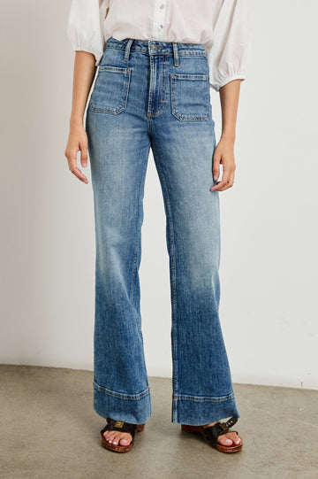 Alamitos high waisted denim trouser with flared leg and front patch pockets in Tradewind - front view on model