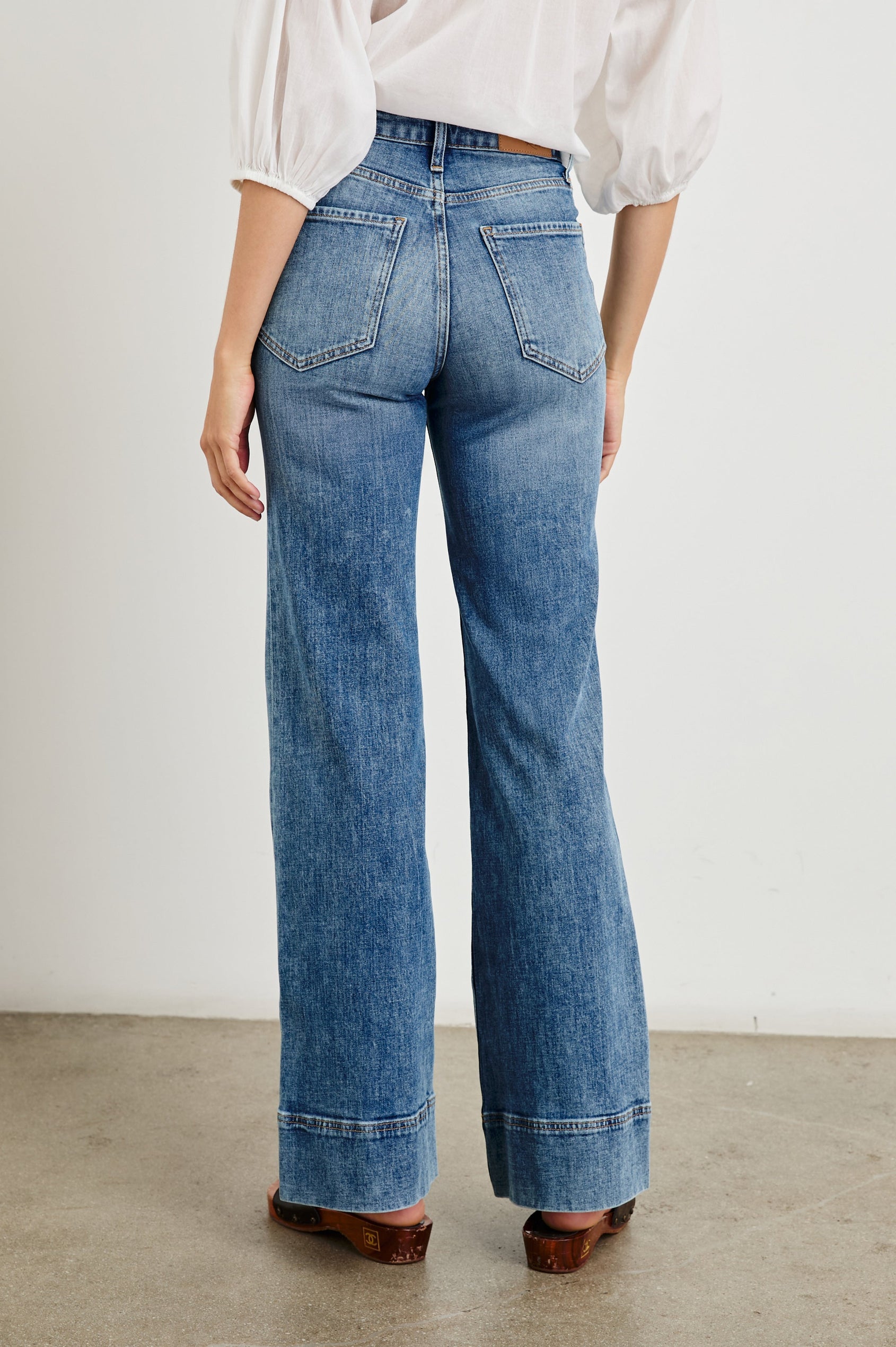 Alamitos high waisted denim trouser with flared leg and front patch pockets in Tradewind - back view on model