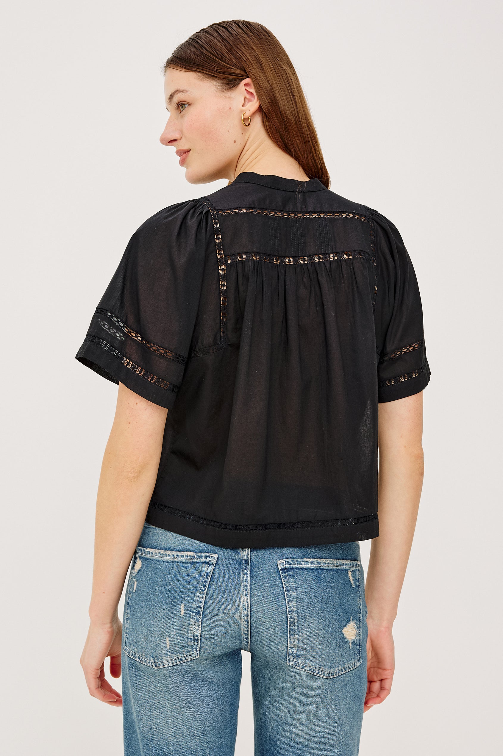 Alanis Shirt in Lightweight Cotton With Split Band V-Neckline, Front Button-and-Loop Closures, Lattice Embroidery, and Short Puff Sleeves in Black Colorway - Upper Body Back View Featured on Model