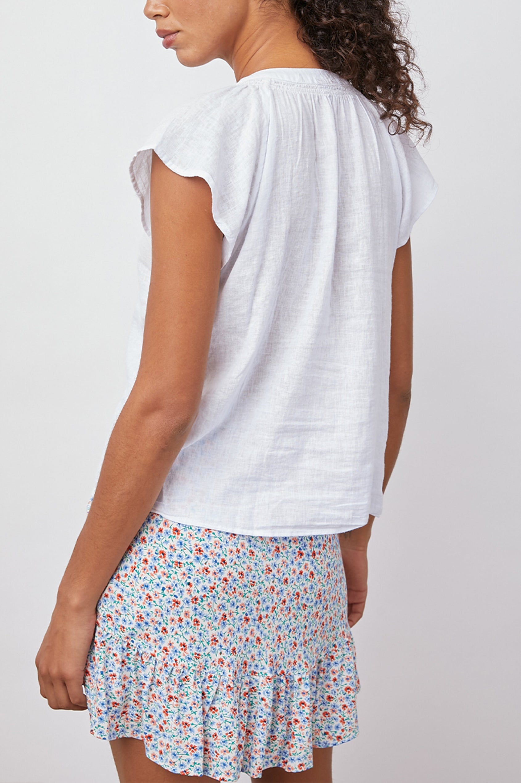 Alena Short Sleeve Top with Flutter Sleeves, a V Neck, Buttons Down the Bodice and Ruching along the Collar in Petal Colorway - Back View Featured on Model