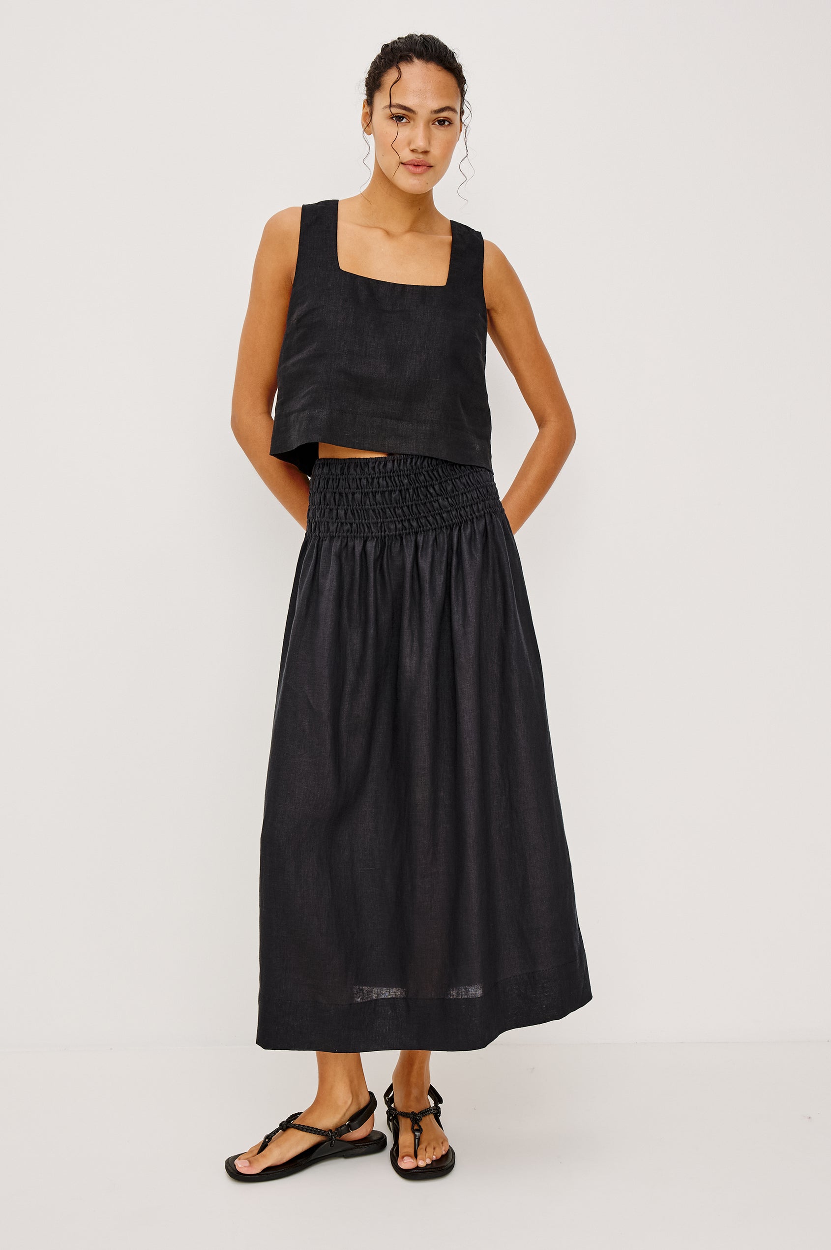 Alessa Midi Skirt in Heavy Linen With Wide Smocked Waistband and A-Line Silhouette in Black Linen Colorway - Full Body Front View Featured on Model