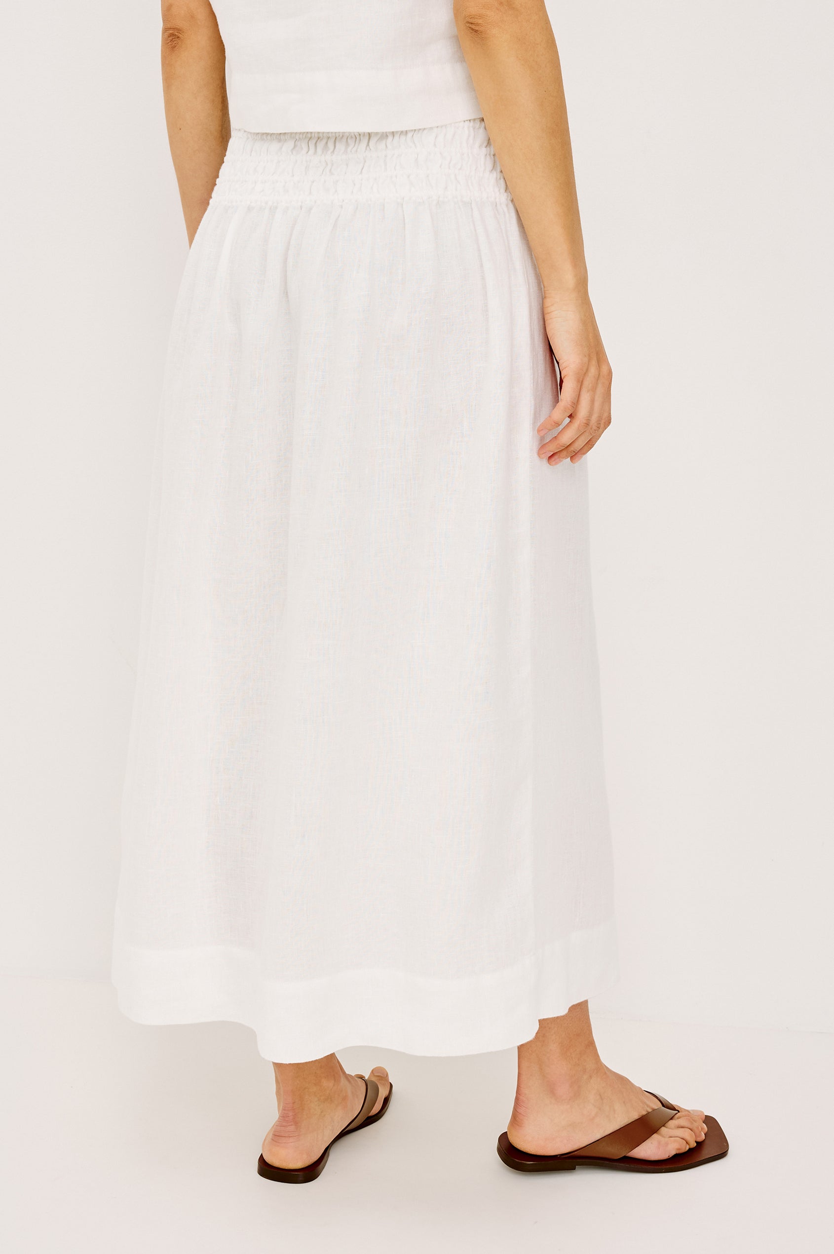 Alessa Midi Skirt in Heavy Linen With Wide Smocked Waistband and A-Line Silhouette in White Colorway - Lower Body Back View Featured on Model