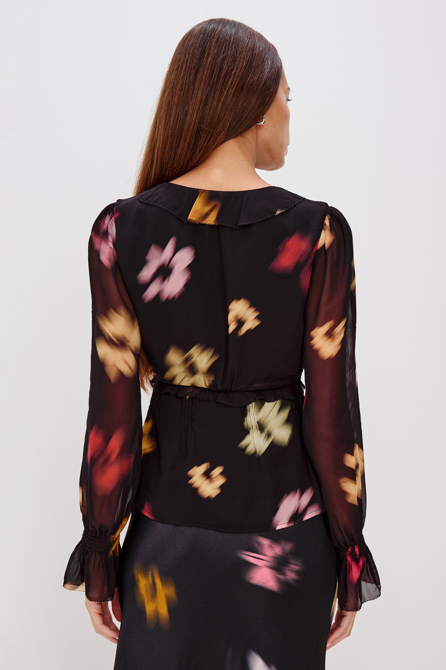 Alixa Blouse in Chiffon With Ruffled Deep V-Neckline, Front Buttons, and Long Balloon Sleeves With Smocked Bell Cuffs in Blurred Floral Colorway - Upper Body Back View Featured on Model