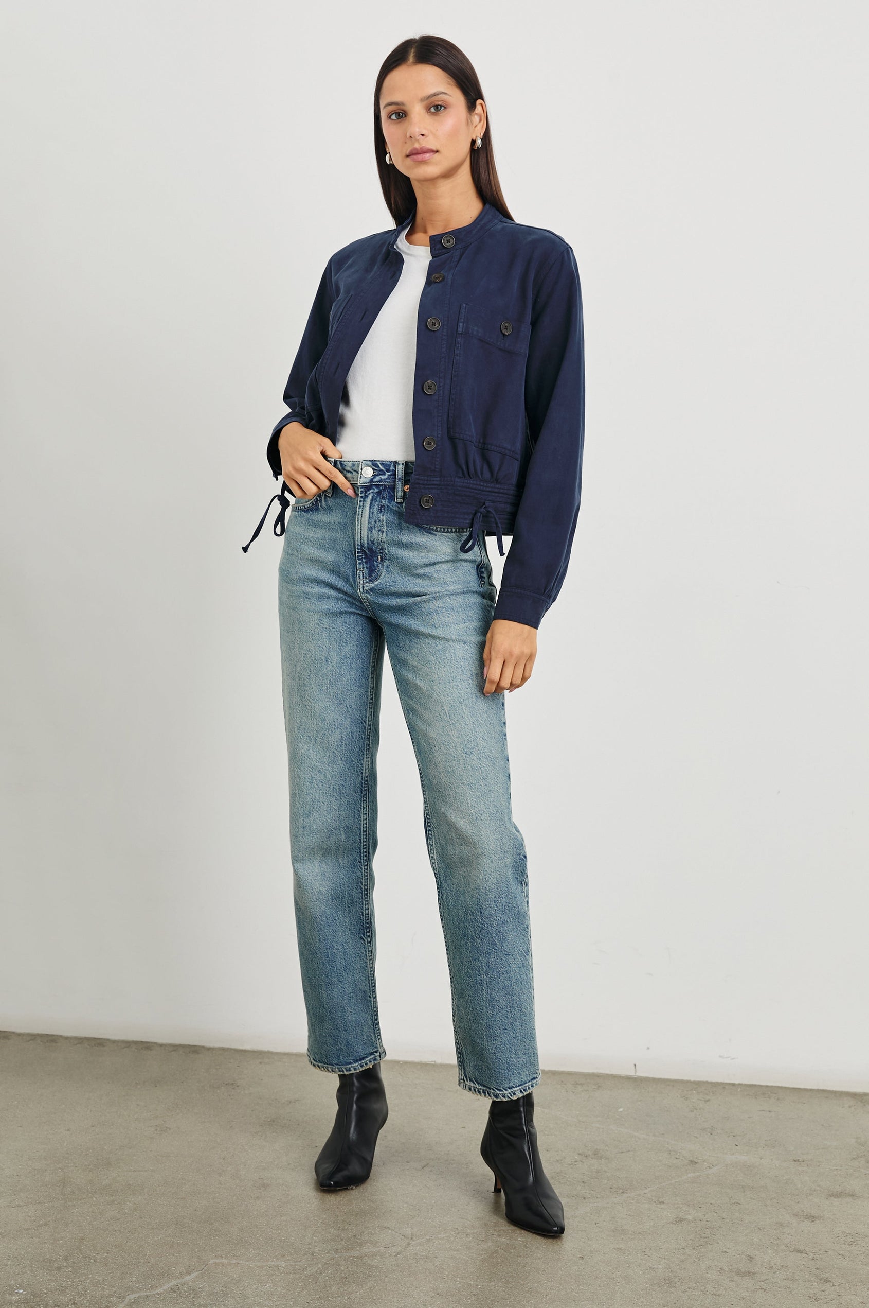 Alma Jacket with Button Closure, Mandarin Collar, Two Large Chest Button Patch Pockets and a Drawcord at the Hem in Navy Colorway - Front Full Body View Featured on Model