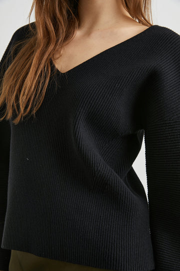 Alondra Ribbed Long-Sleeve Sweater with a Deep V Neck and Puff Sleeves in Black Colorway - Front View Featured on Model 