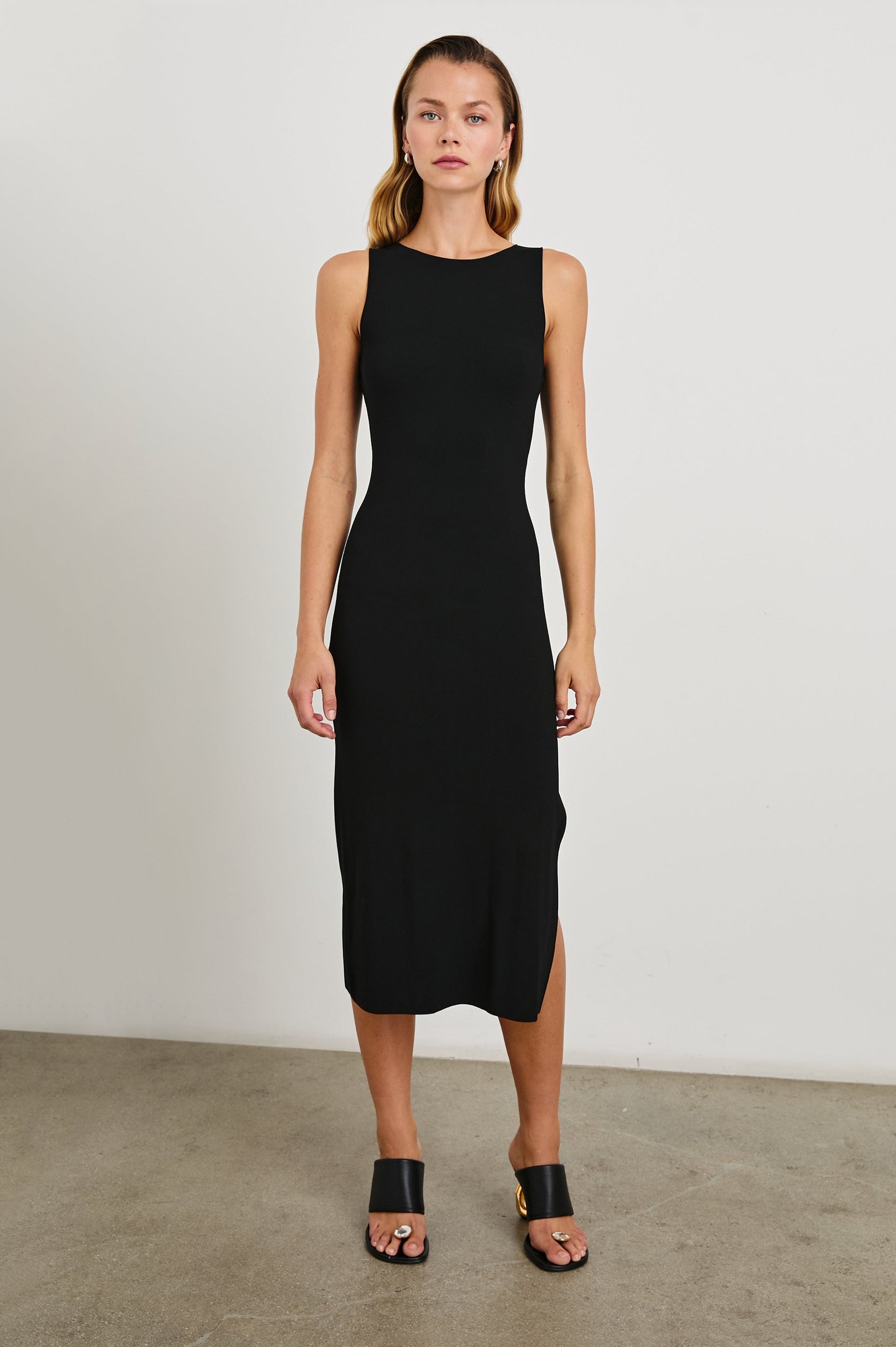 Alora Sleeveless Midi Dress with a Shallow Boat Neck, Mid-Thigh Side Slit, and a Fine Rib Knit in Black Colorway - Front Full Body View Featured on Model