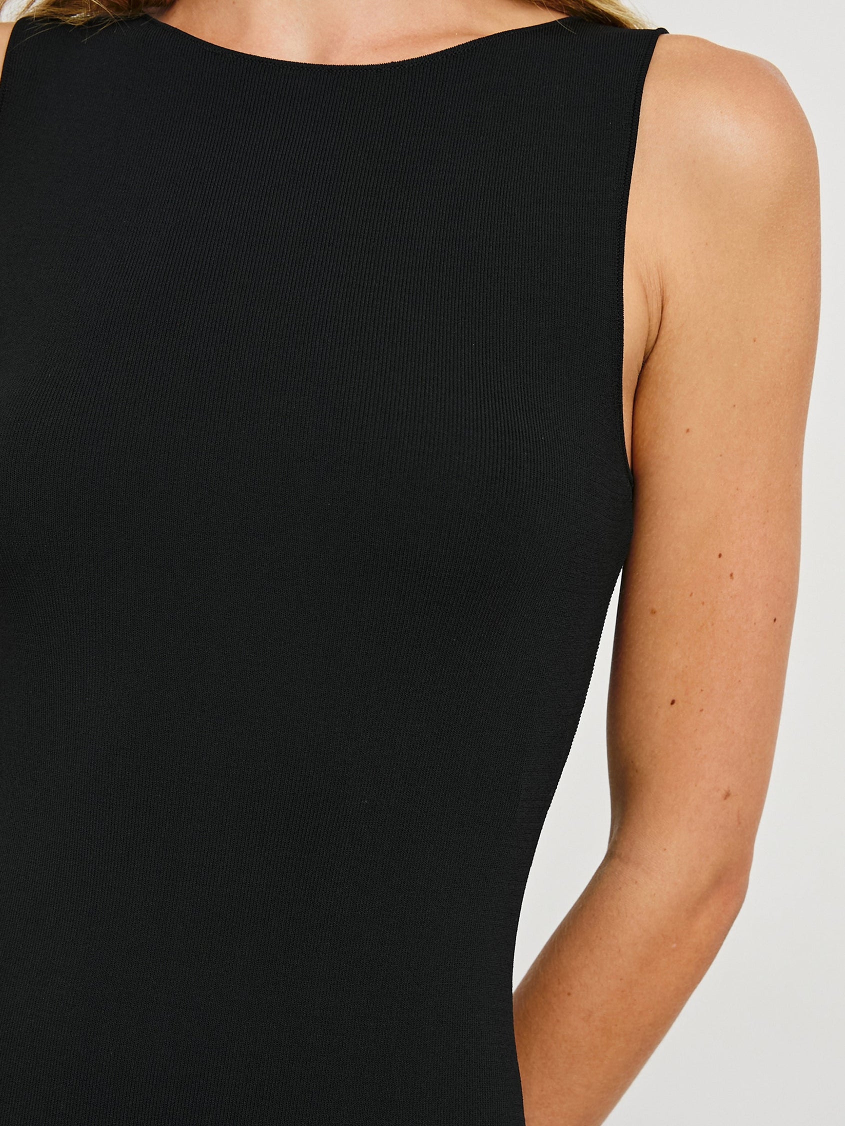 Alora Sleeveless Midi Dress with a Shallow Boat Neck, Mid-Thigh Side Slit, and a Fine Rib Knit in Black Colorway - Front View Featured on Model