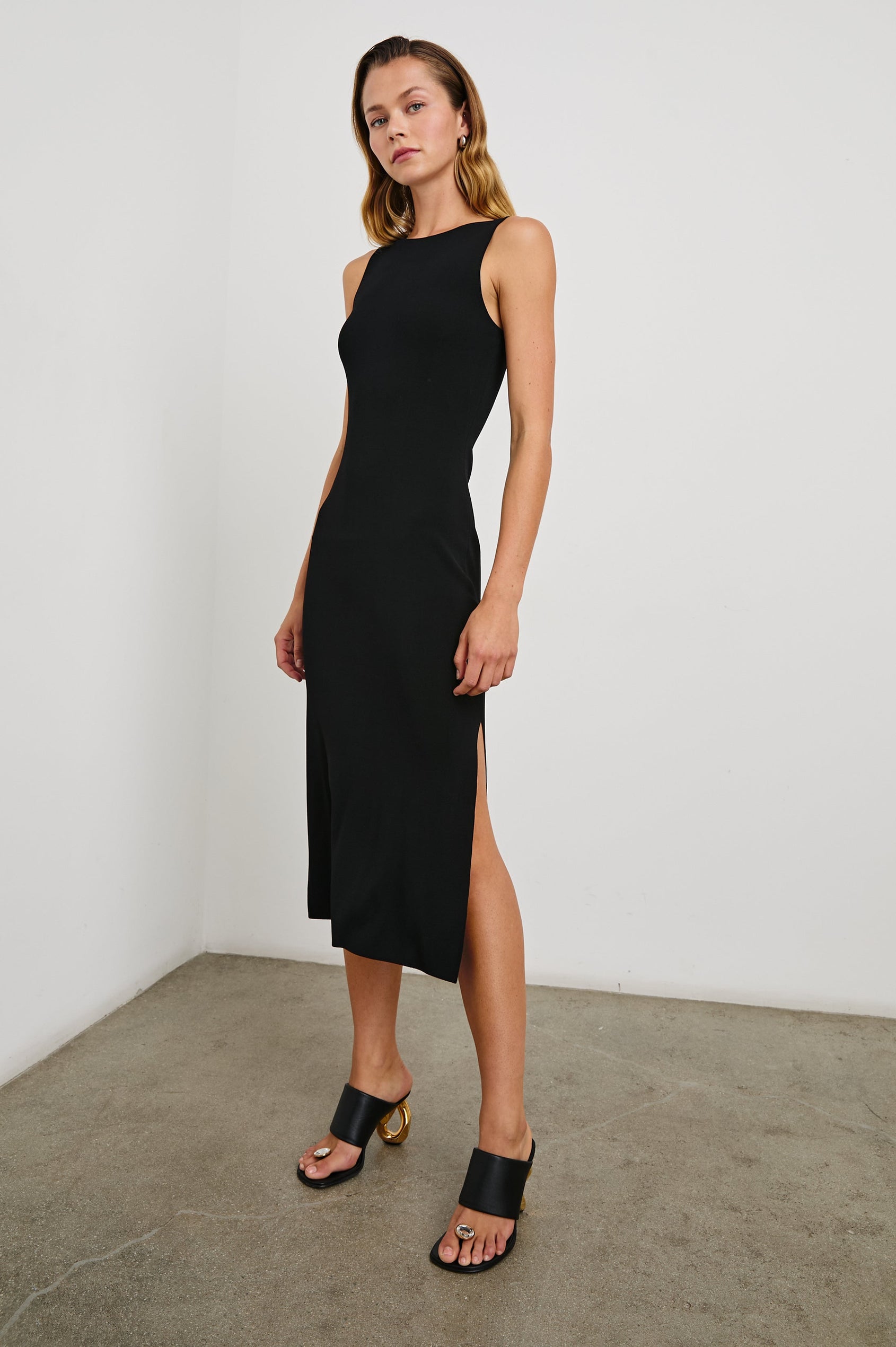 Alora Sleeveless Midi Dress with a Shallow Boat Neck, Mid-Thigh Side Slit, and a Fine Rib Knit in Black Colorway - Front Full Body View Featured on Model