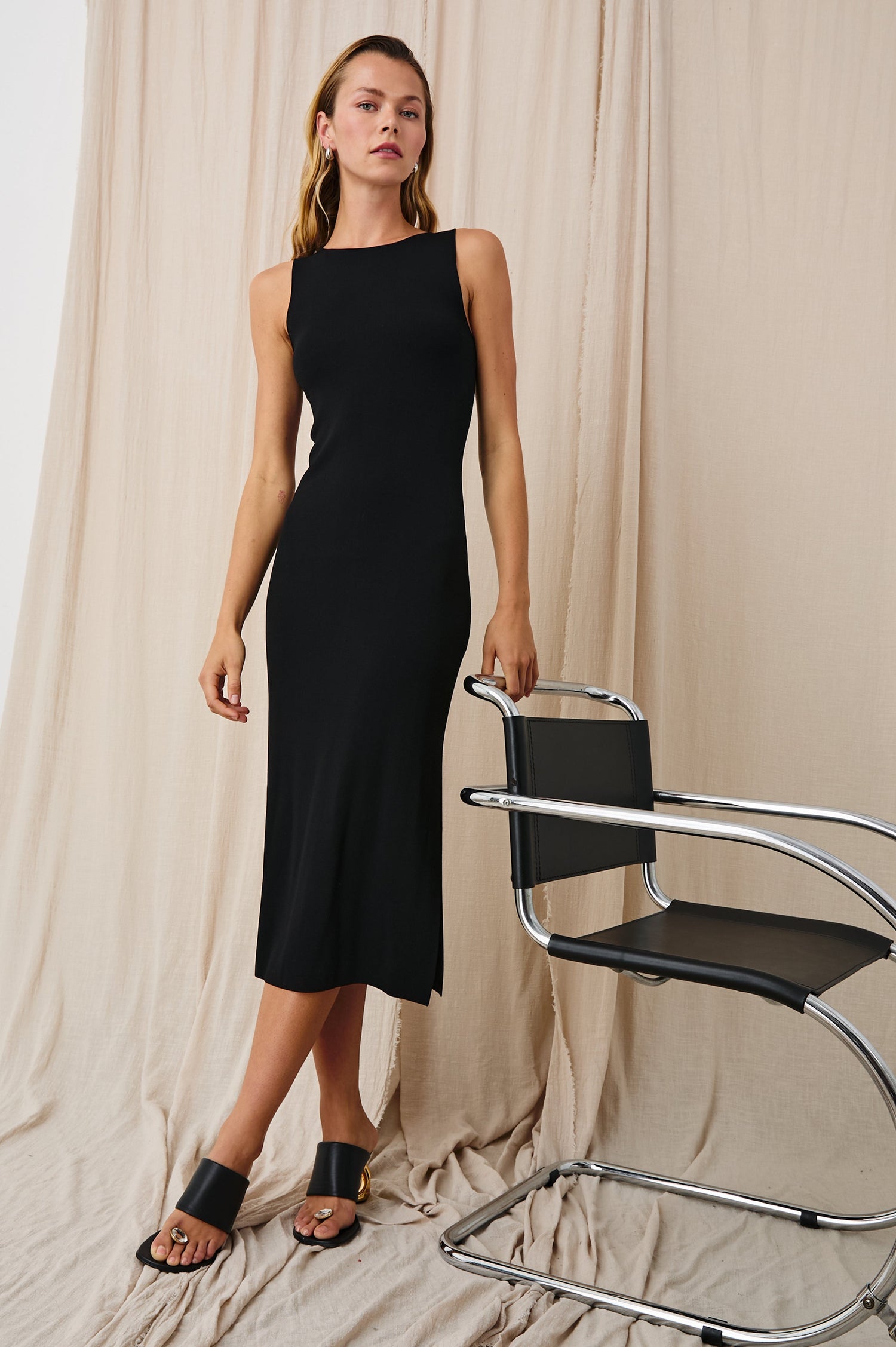 Alora Sleeveless Midi Dress with a Shallow Boat Neck, Mid-Thigh Side Slit, and a Fine Rib Knit in Black Colorway - Front Full Body View Featured on Model