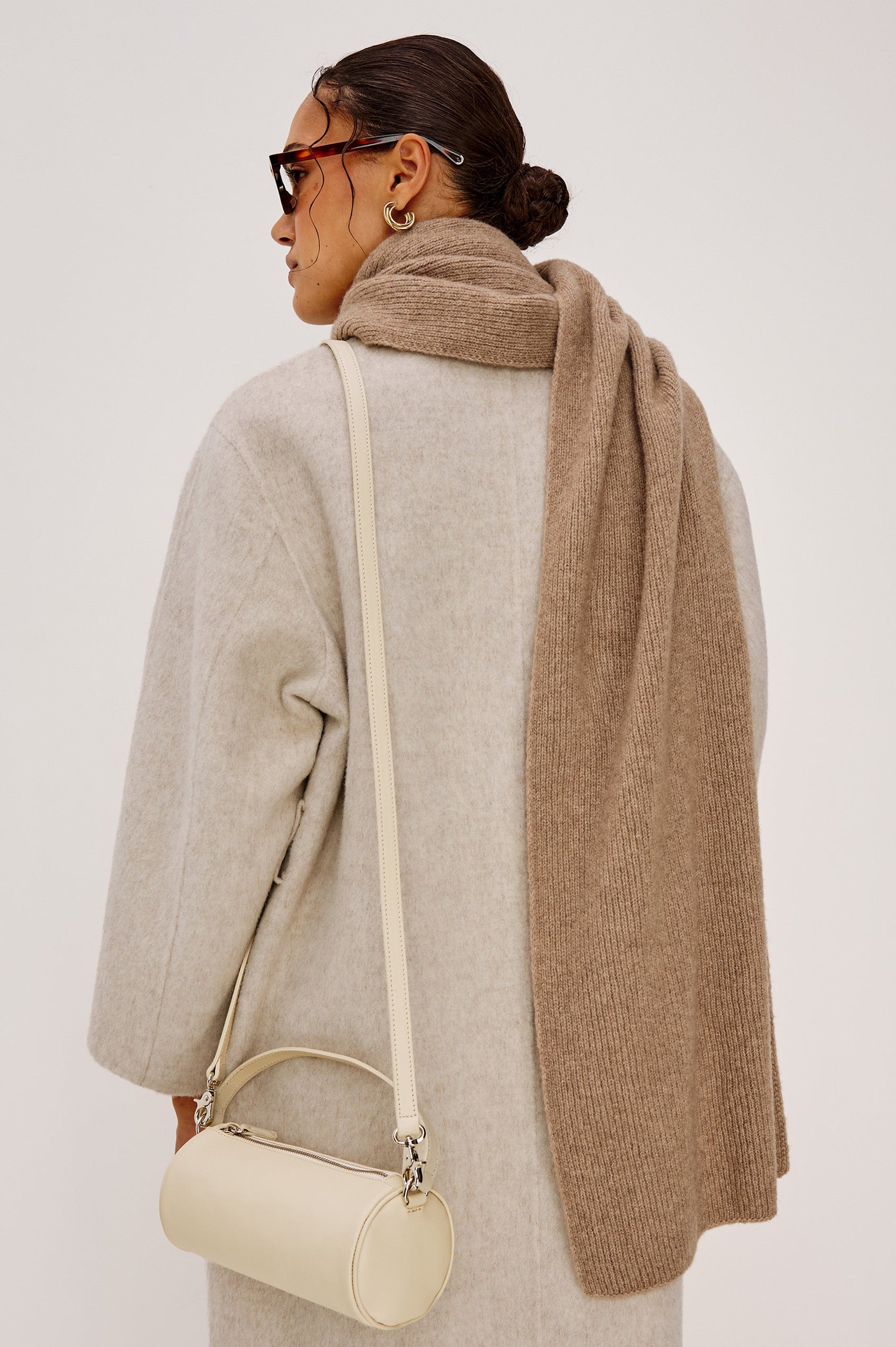 Alps is a cashmere scarf in Oat colorway. Back view featured on model.
