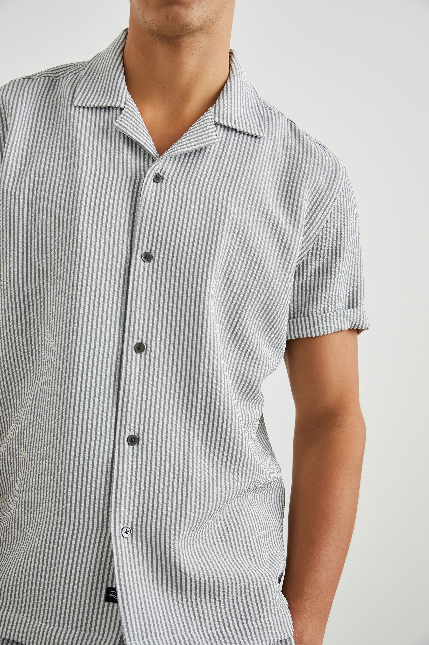 Amalfi Short-Sleeve Button Up in Faded Seersucker Colorway, Grey and white thin vertical stripes  - Front View Featured on Model