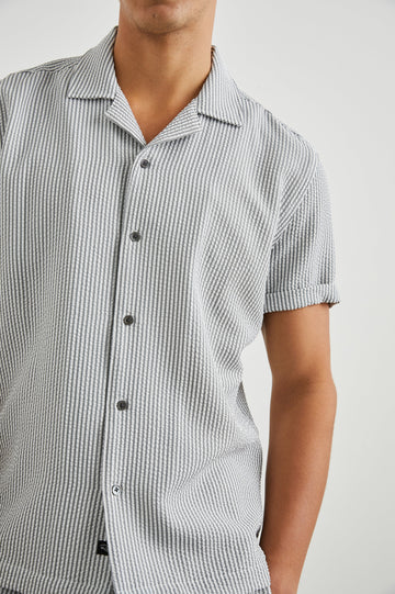 Amalfi Short-Sleeve Button Up in Faded Seersucker Colorway, Grey and white thin vertical stripes  - Front View Featured on Model