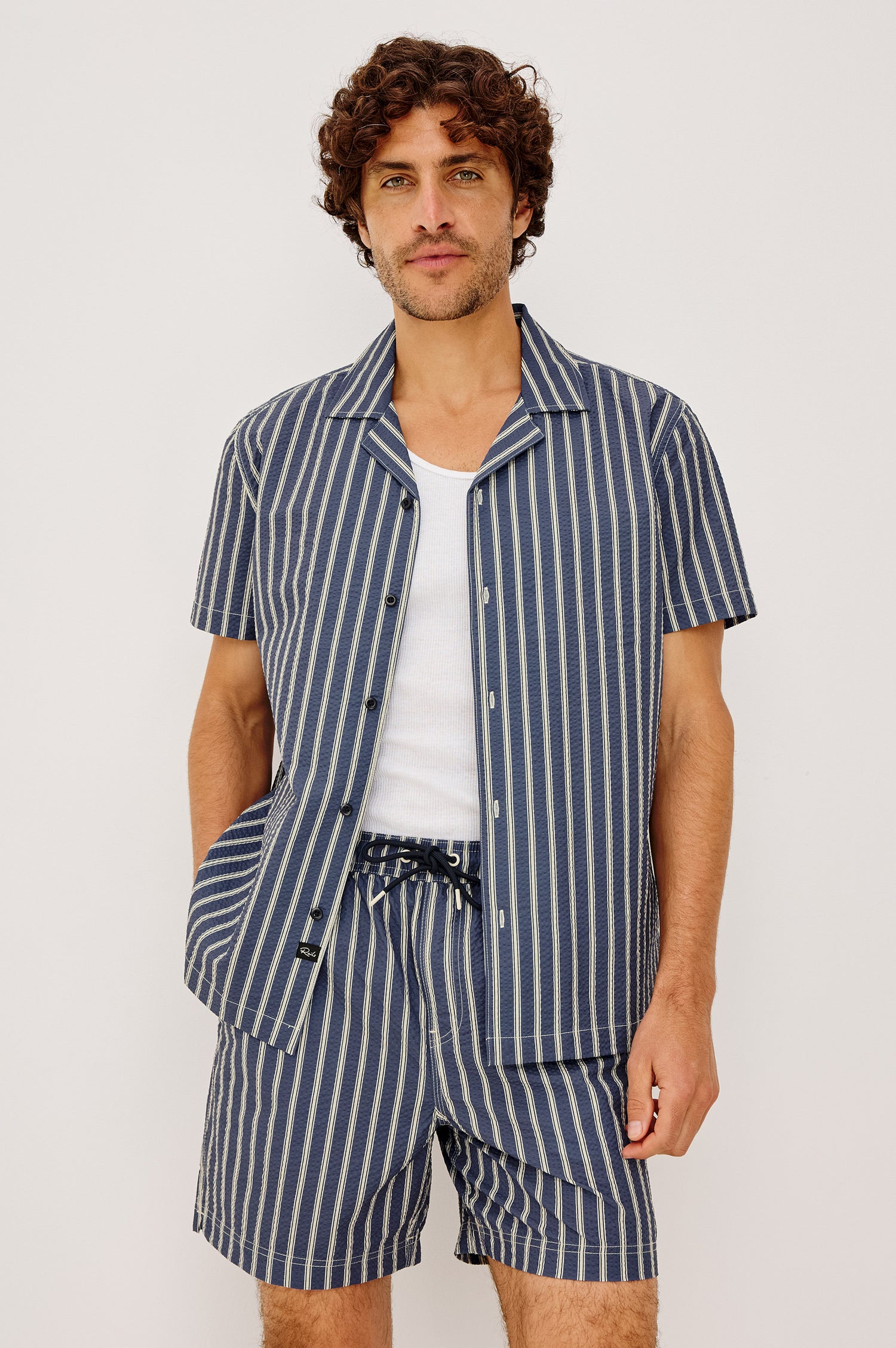 Amalfi Camp Shirt in Lightweight Seersucker With Notched Collar, Front Buttons, Short Sleeves, and Relaxed Fit in Navy Cream Stripe Colorway - Upper Body Front View Featured on Model