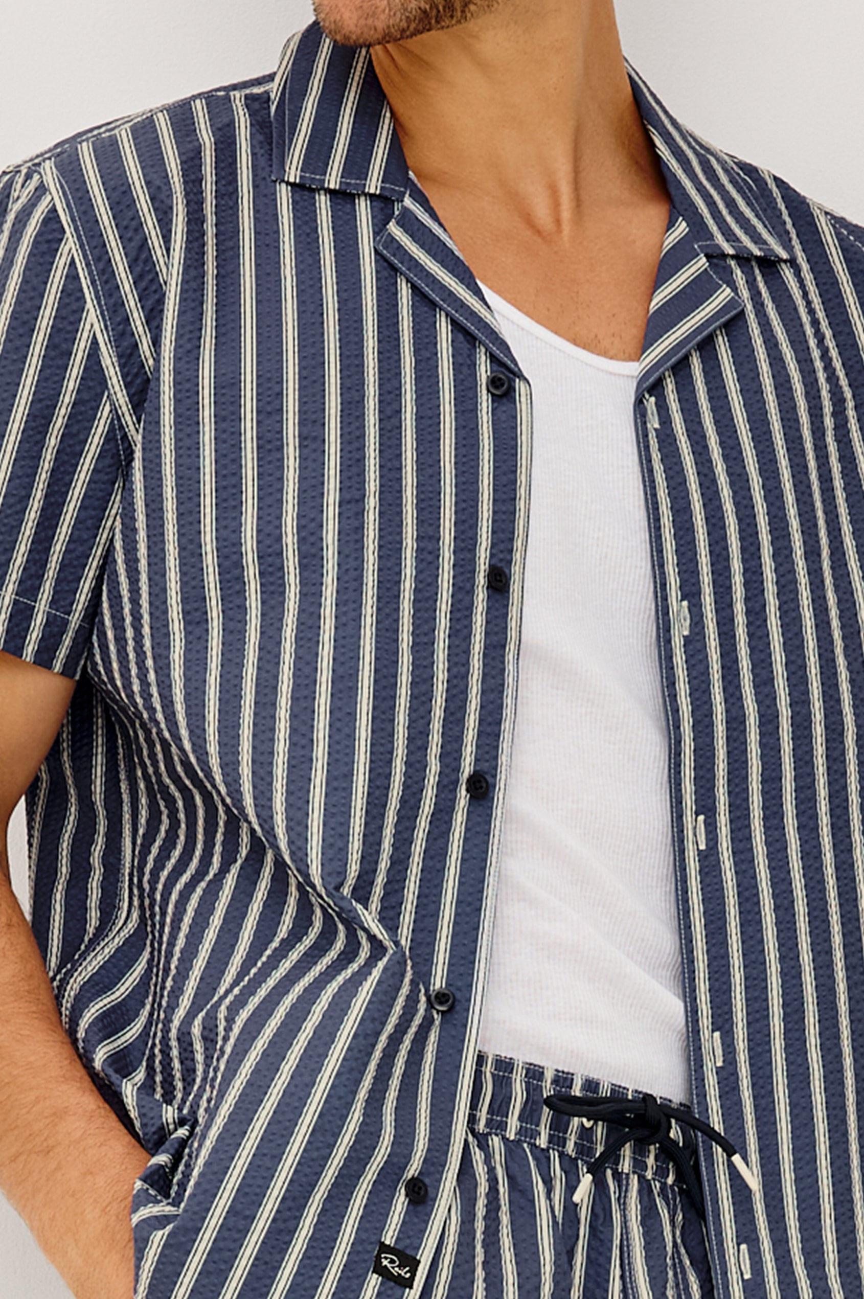 Amalfi Camp Shirt in Lightweight Seersucker With Notched Collar, Front Buttons, Short Sleeves, and Relaxed Fit in Navy Cream Stripe Colorway - Upper Body Front View Featured on Model