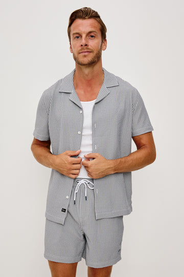 The Amalfi Button-Up Short Sleeve Shirt in Lightweight Stretch Linen-Blend With a Notched Collar and Classic Fit in Navy Deck Stripe - Upper Body Front View Featured on Model