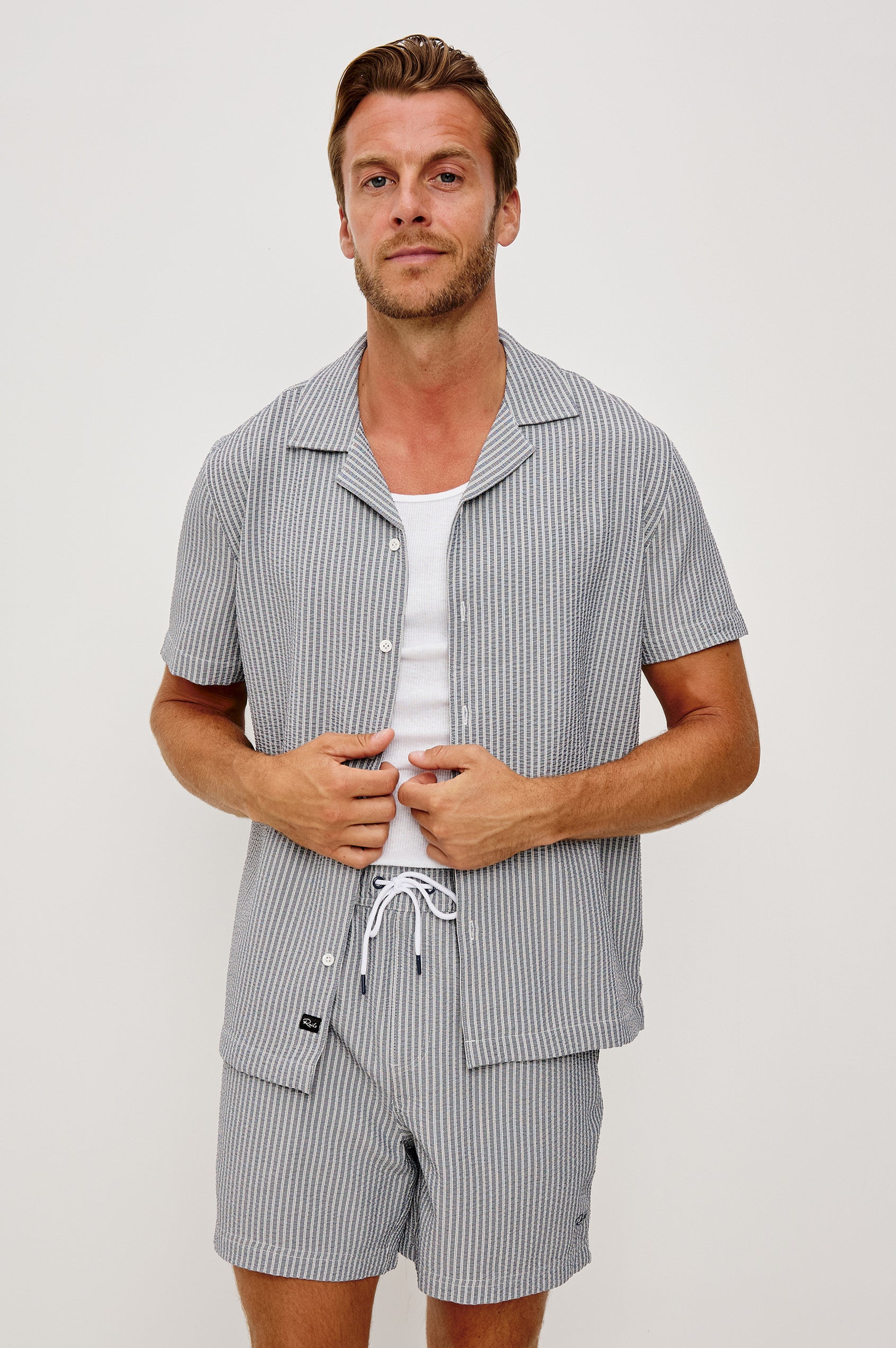 The Amalfi Button-Up Short Sleeve Shirt in Lightweight Stretch Linen-Blend With a Notched Collar and Classic Fit in Navy Deck Stripe - Upper Body Front View Featured on Model