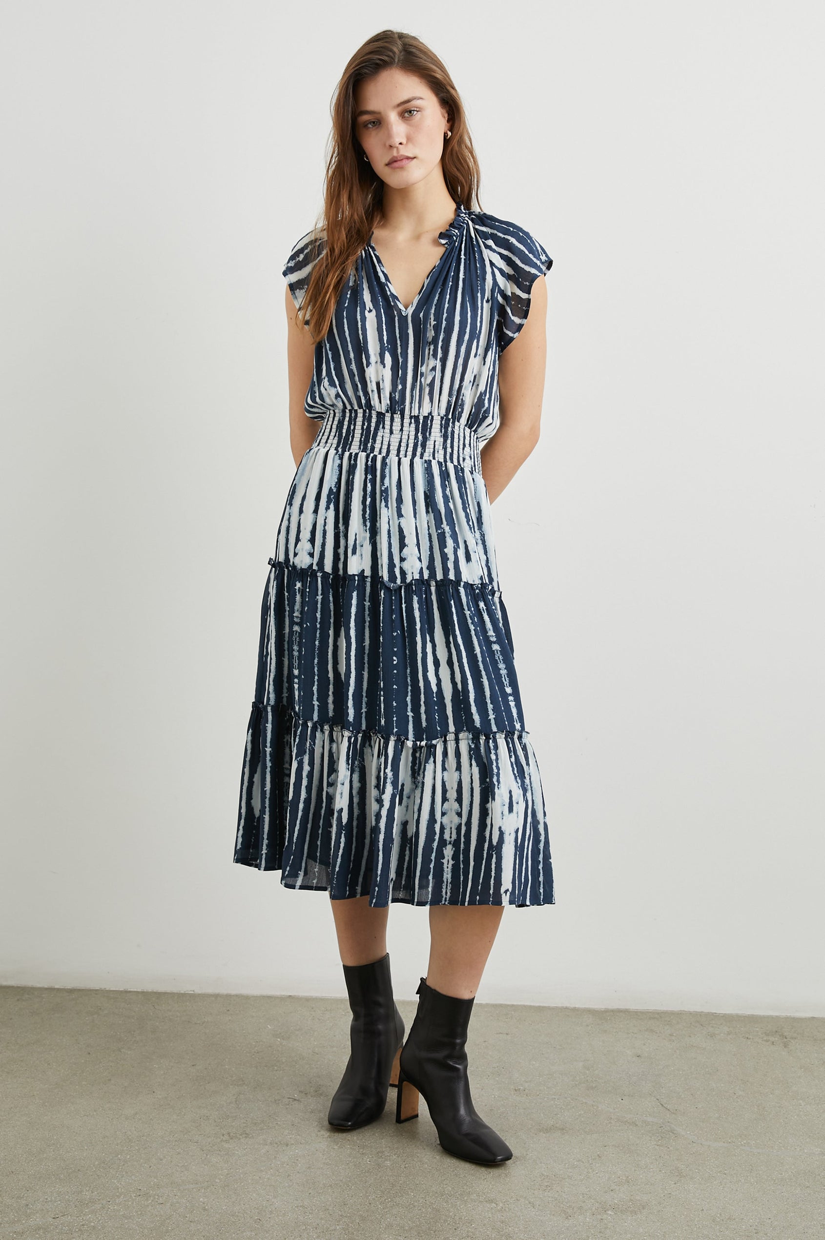 Amellia Short-Sleeve Midi Dress with Smocked Waist and Collar, V Neck, and a Tiered Skirt in Indigo Nile Stripe Colorway, White and Indigo Streaks - Front Full Body View Featured on Model