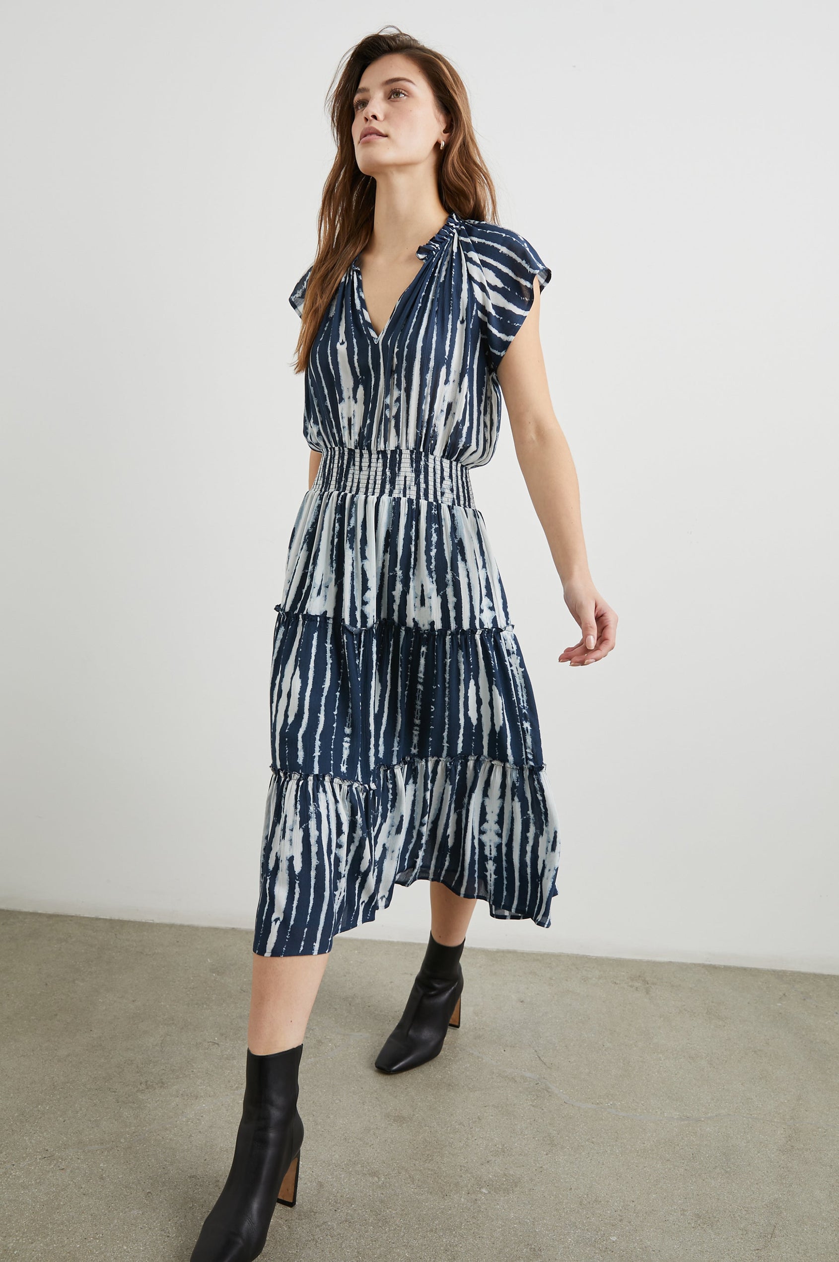 Amellia Short-Sleeve Midi Dress with Smocked Waist and Collar, V Neck, and a Tiered Skirt in Indigo Nile Stripe Colorway, White and Indigo Streaks - Front Full Body View Featured on Model