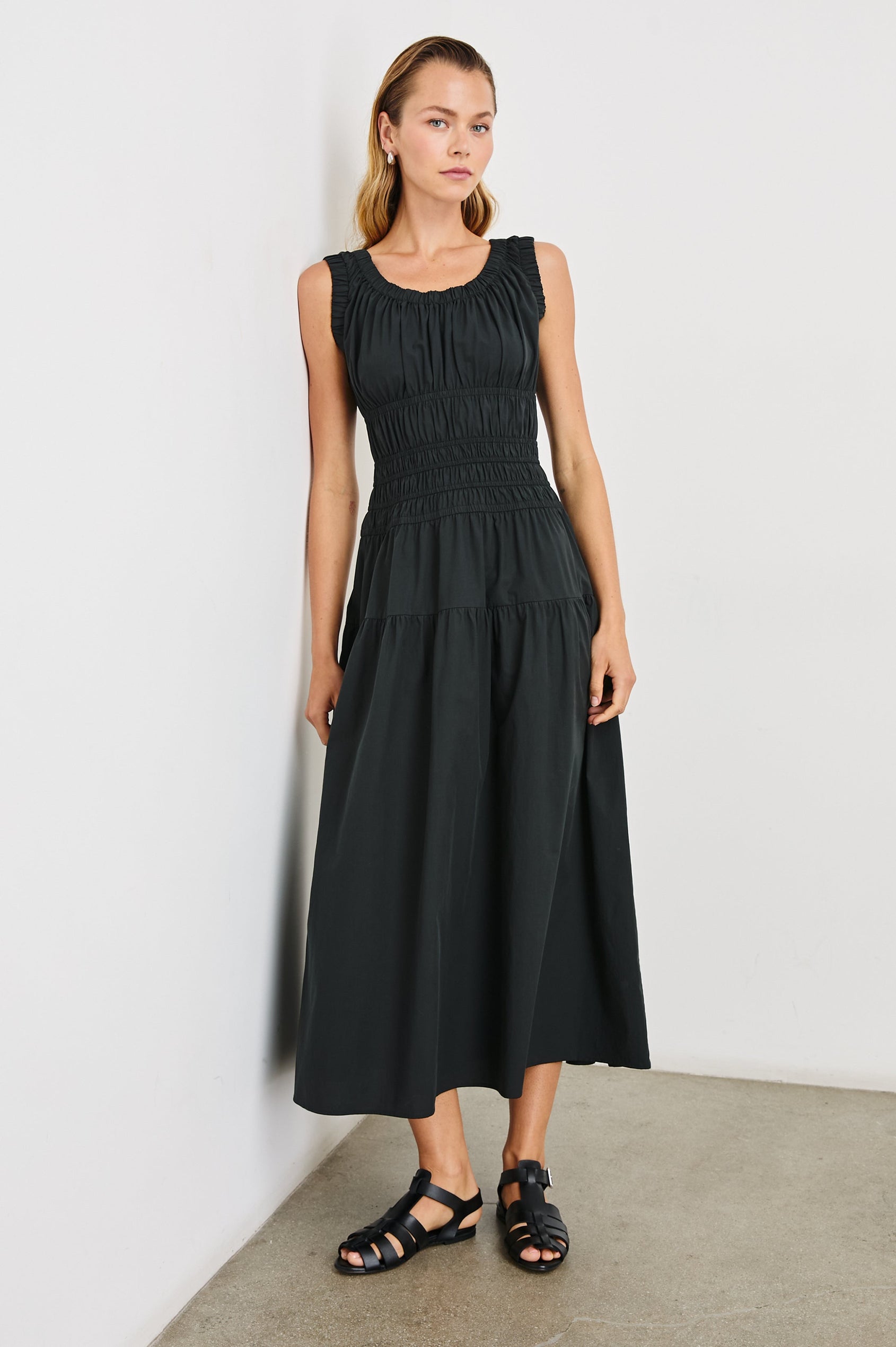 Anastasia Sleeveless Tiered Midi Dress with Shoulder Straps, a Scoop Neck and Ruching on the Bodice in Black Colorway - Front Full Body View Featured on Model  