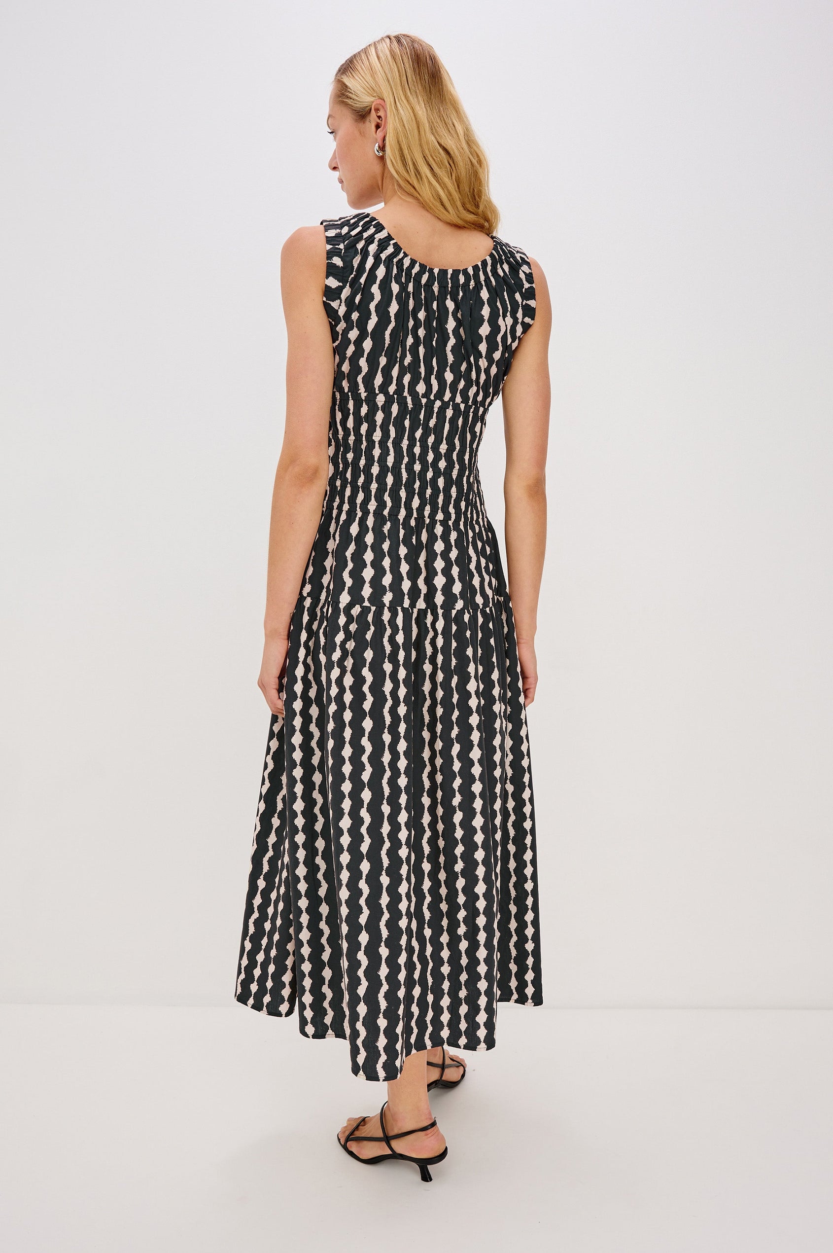 Anastasia Sleeveless Tiered Midi Dress with Shoulder Straps, a Scoop Neck and Ruching on the Bodice in Painted Noir Colorway - full body back view on model