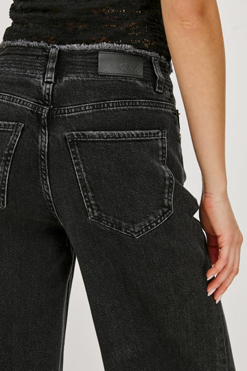 Angeleno mid rise slouchy wide leg jean with a drawstring waist tie, gromets and a raw edge waistband in a black wash Ash Black - back view featured on model.