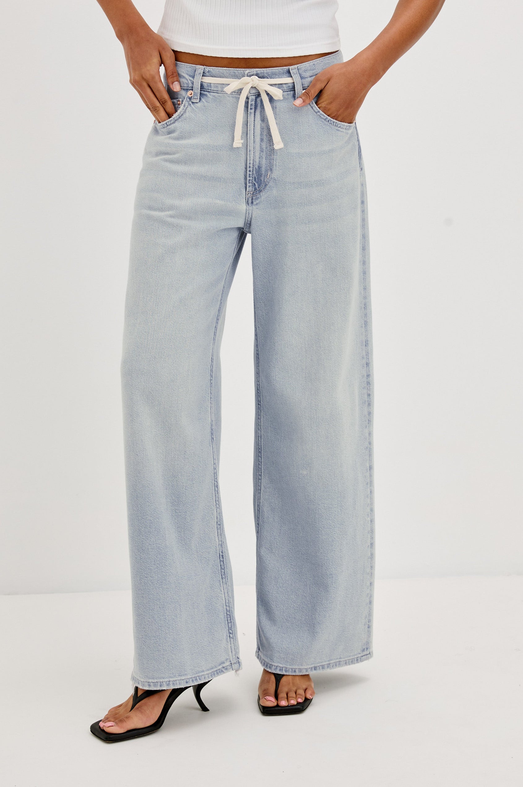 Angeleno Crop Denim Pant, Wide Leg, Five Pocket Zip Fly with a White Drawstring Tie at Waist in Light Wash Scuba Colorway. Front View Shown on Model.