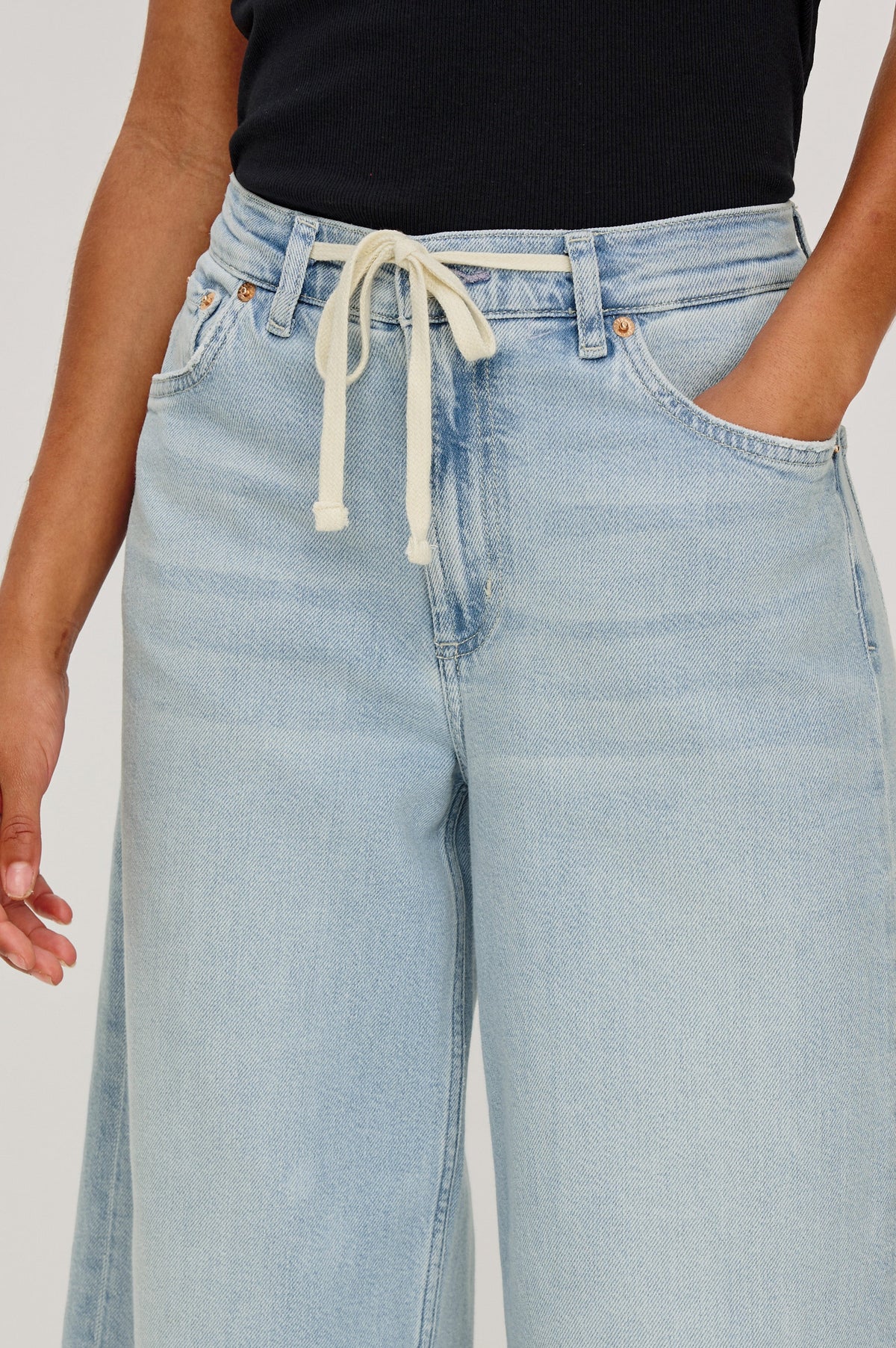 Angeleno Crop Denim Pant, Wide Leg, Five Pocket Zip Fly with a White Drawstring Tie at Waist in Light Wash Scuba Colorway. Front Close up View Shown on Model.