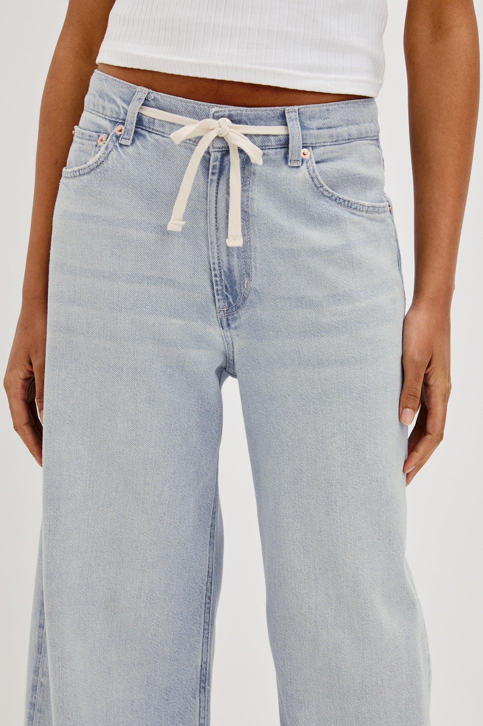 Angeleno Crop Denim Pant, Wide Leg, Five Pocket Zip Fly with a White Drawstring Tie at Waist in Light Wash Scuba Colorway. Front Detailed View Shown on Model.