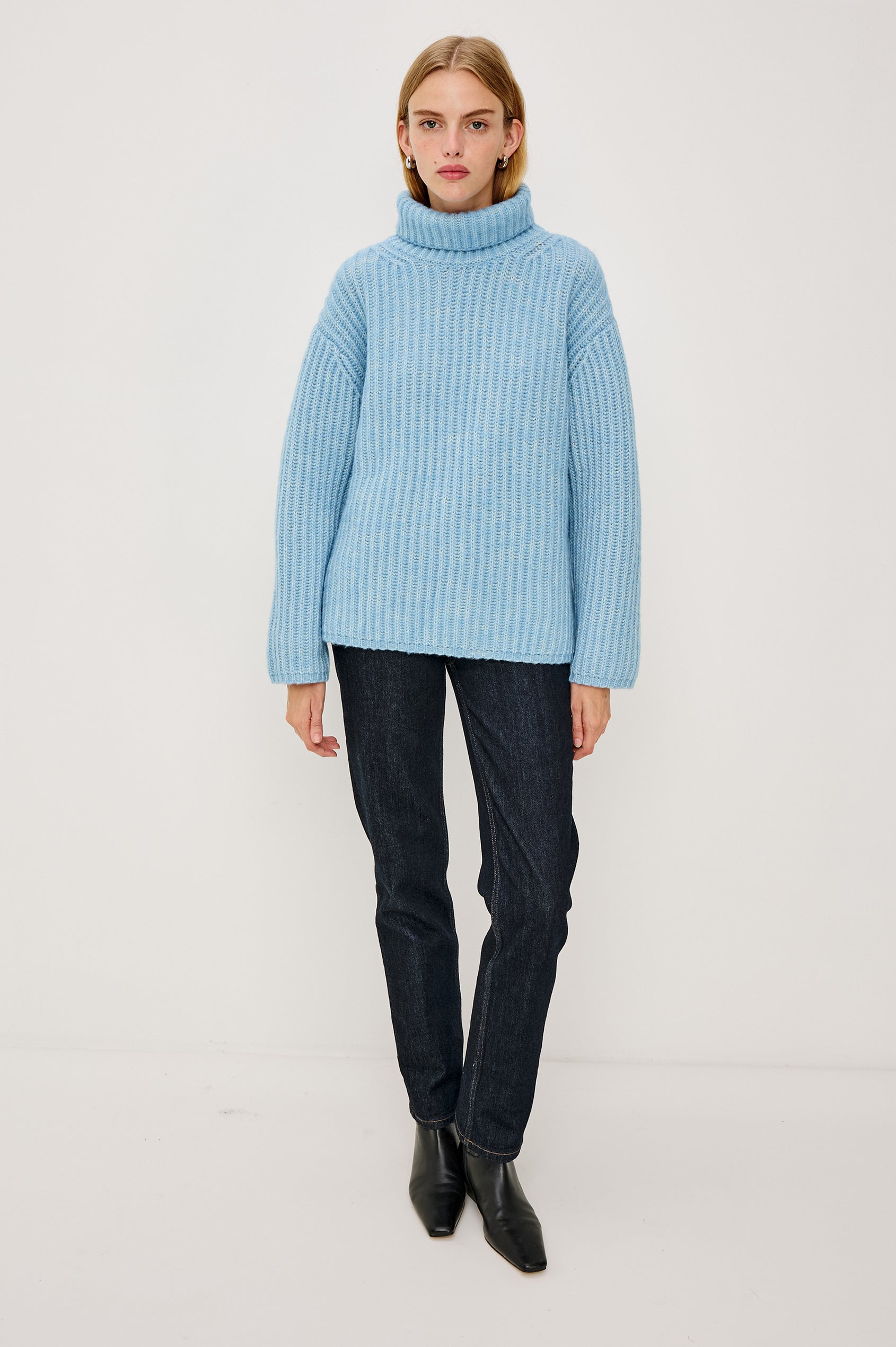 Anja Turtleneck Sweater in Soft Ribbed Knit With Relaxed Fit, High Low Hem, and Long Sleeves in Light Blue Colorway - Full Body Front View Featured on Model