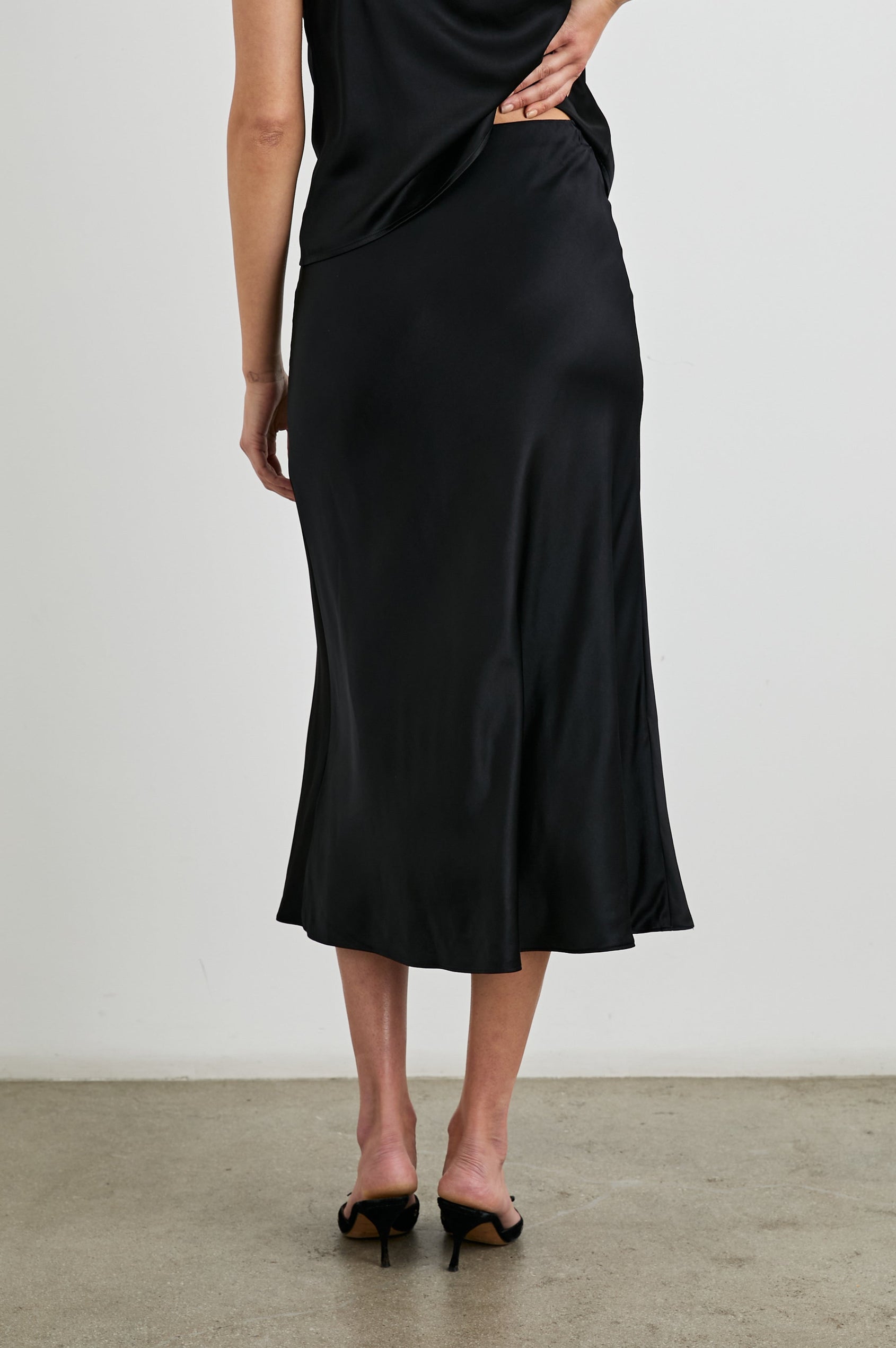 Anya High-waisted Midi Skirt in Black Colorway - Back View Featured on Model