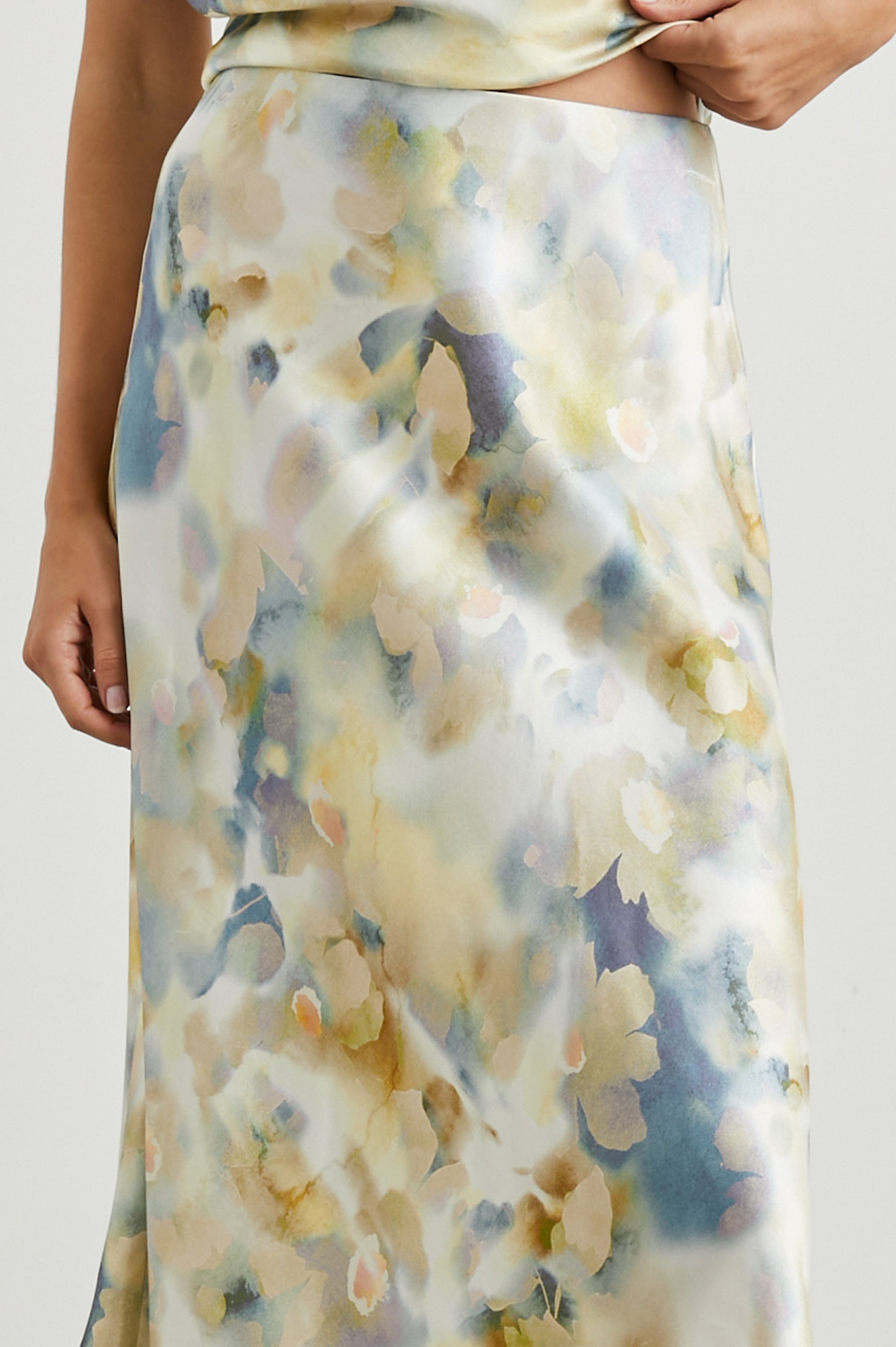 Anya High-waisted Midi Skirt in Diffused Blossom Colorway, with flowers in Creams, Golds and Blues on White - Front View Featured on Model