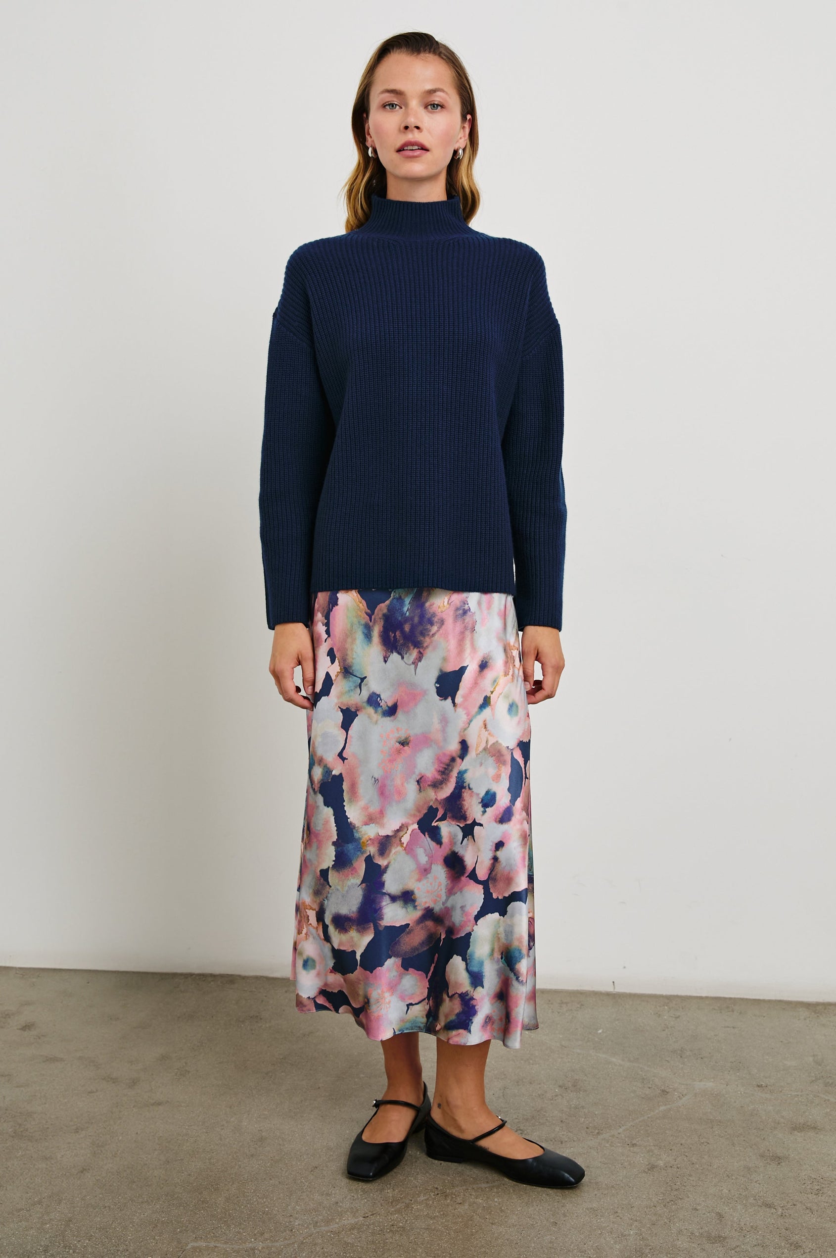 Anya High-waisted Midi Skirt in Midnight Verbena Colorway, Flowers in Pinks, Purples, Oranges and Blues on dark blue - Front Full Body View Featured on Model