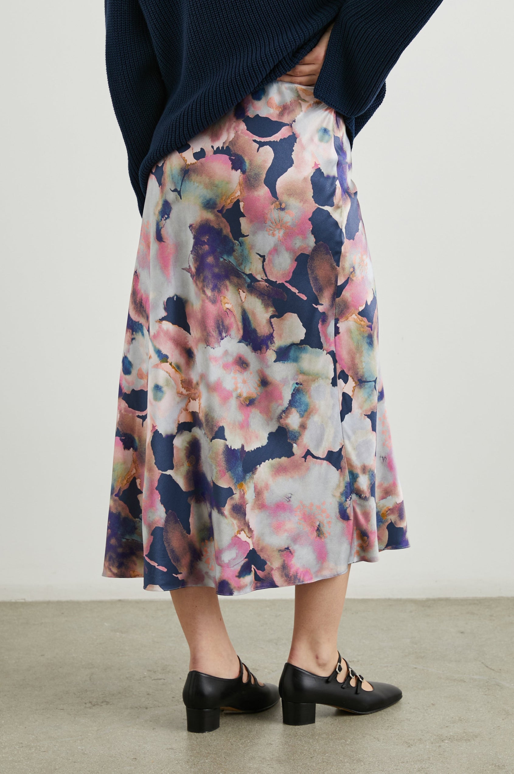 Anya High-waisted Midi Skirt in Midnight Verbena Colorway, Flowers in Pinks, Purples, Oranges and Blues on dark blue - Back View Featured on Model
