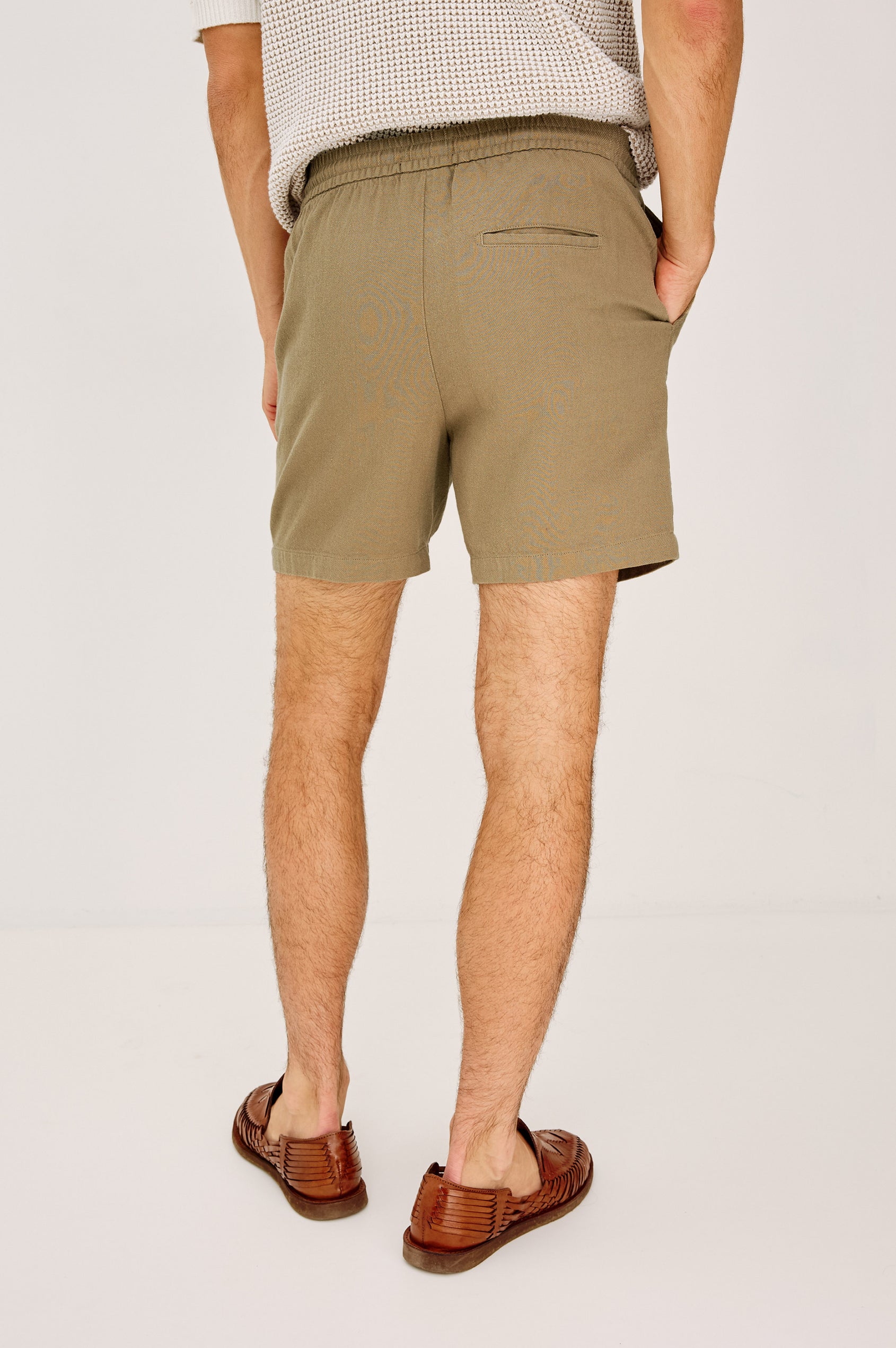 Archer Short in Heavy Linen With Relaxed Fit, Elastic Drawstring Waist, Front Zip Fly, 6″ Inseam, and Side Pockets in Washed Blue Colorway - Lower Body Back View Featured on Model