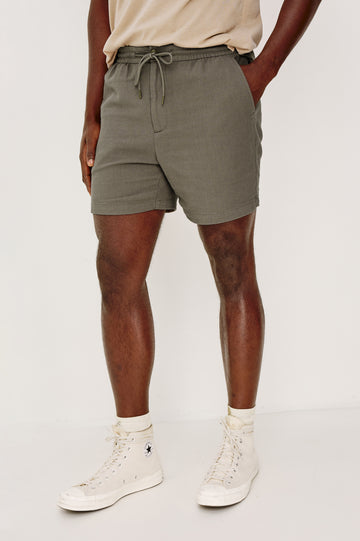 Archer Short in Unlined Cotton Linen With Relaxed Fit, Adjustable Waist Drawstring Ties, Side Pockts, and 6-Inch Inseam in Fallen Rock Colorway - Lower Body Front View Featured on Model