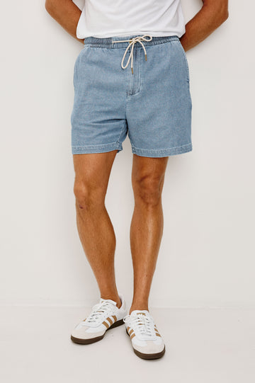 Archer Short in Unlined Cotton Linen With Relaxed Fit, Adjustable Waist Drawstring Ties, Side Pockts, and 6-Inch Inseam in Medium Wash Indigo Colorway - Front View Featured on Model