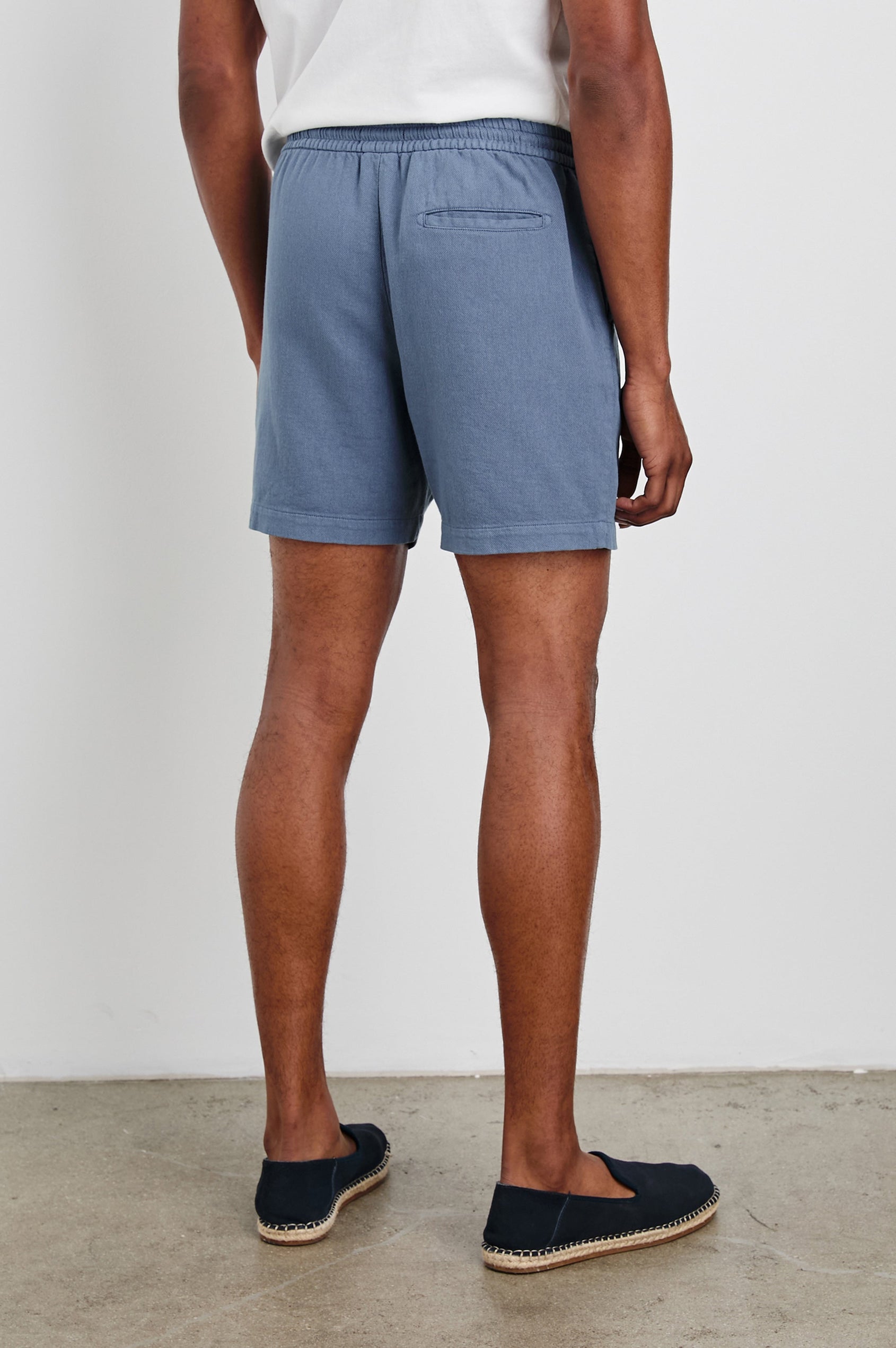 Archer 6" Shorts with a Drawstring Waist, Zipper Fly with Button, Two Front Pockets and a Back Patch Pocket in Washed Blue Colorway - Back View Featured on Model
