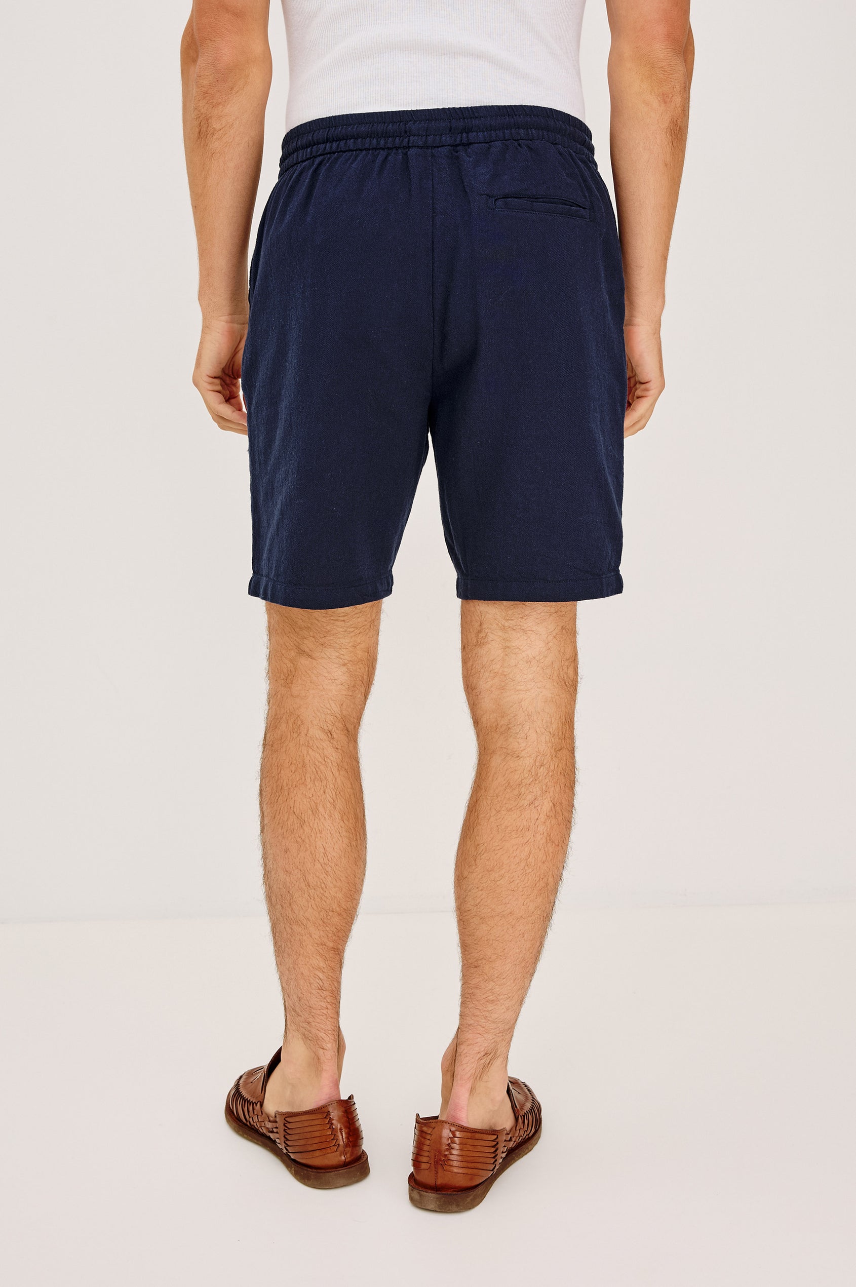 Archer Short in Cotton-Linen Blend With 8.5″ Inseam, Relaxed Fit, Elastic Drawstring Waist, Front Zip Fly, Side Pockets, and Back Welt Pocket in Deep Meridian Colorway - Lower Body Back View Featured on Model