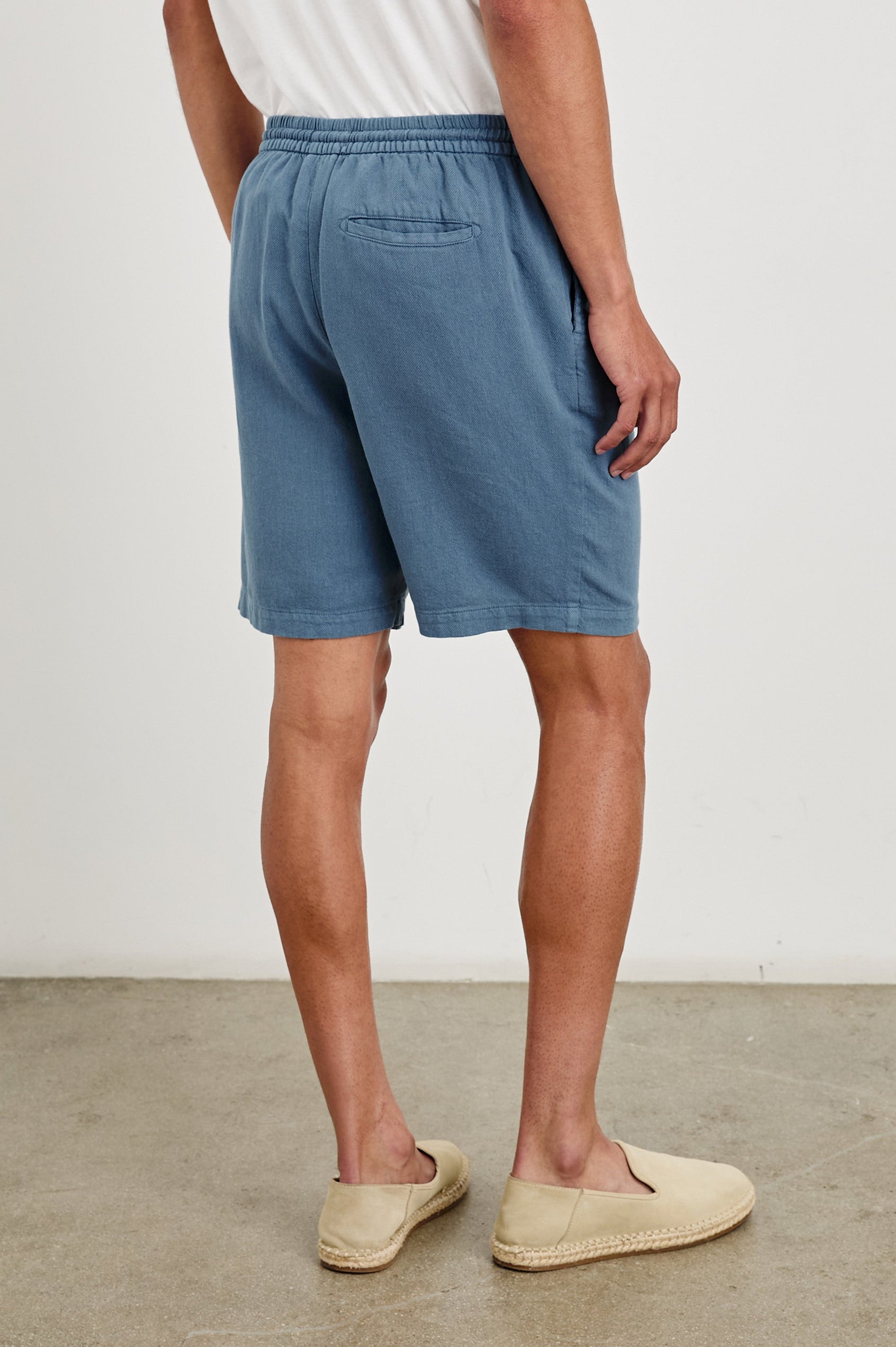 Archer long length cotton short with adjustable drawstring and front button closure in Washed Blue - back view on model.