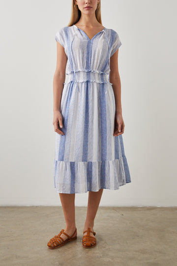 Ashlyn Short Sleeve Midi Dress with a V neck with Ties, a Smocked Waist and a Ruffle Tier at the Hem in Nevis Stripe Colorway, Vertical Stripes in Blue on White - Front Full Body View Featured on Model